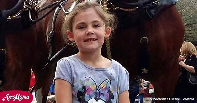 Ein Vater macht Fotos davon, wie seine kleine Tochter mit einem Pferd posiert, und kann sein Lachen nicht zurückhalten, als er das sieht