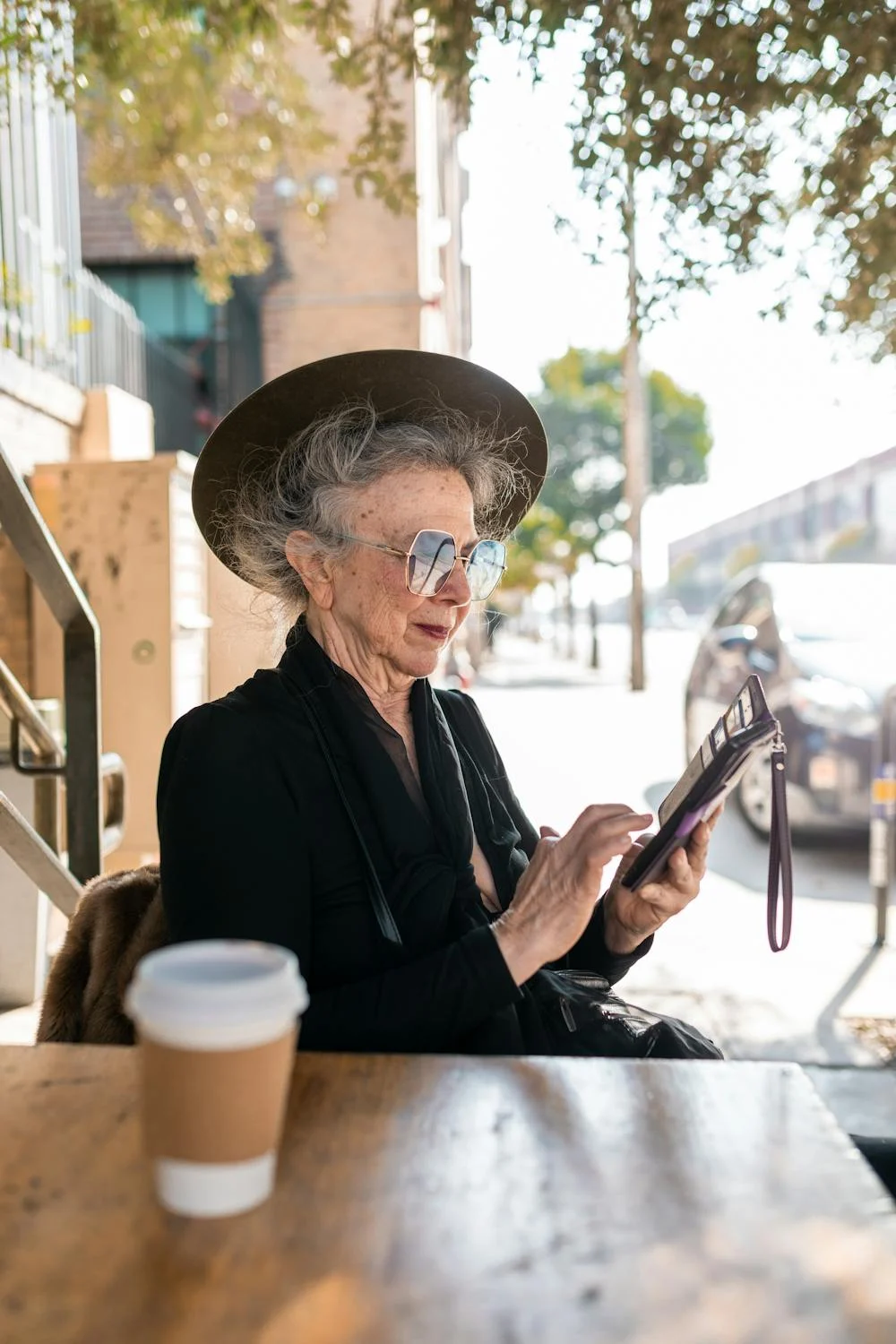 Eine ältere Frau, die in einem Café auf ihrem Telefon tippt | Quelle: Pexels