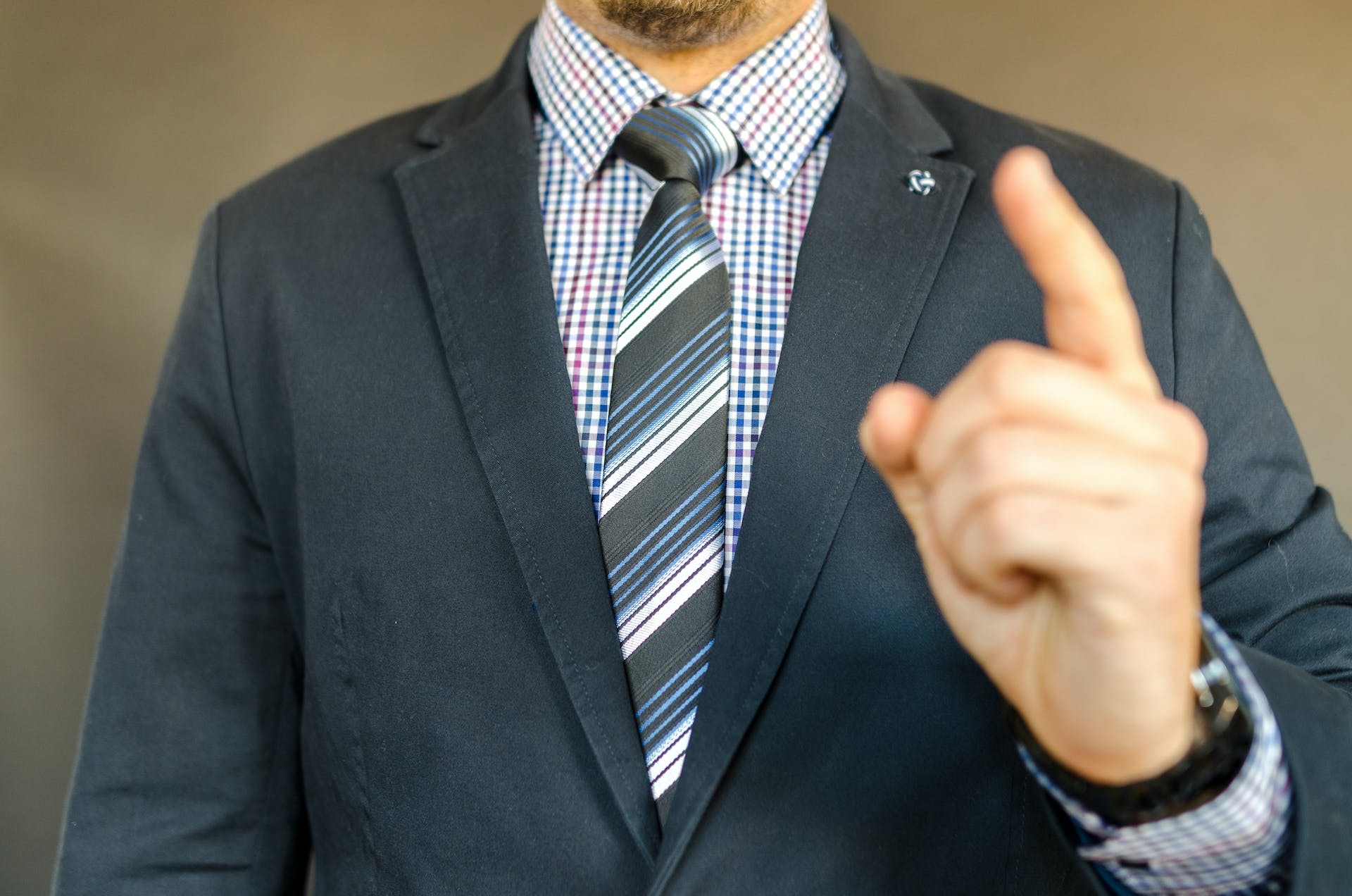 Mann im Anzug zeigt mit dem Finger | Quelle: Pexels