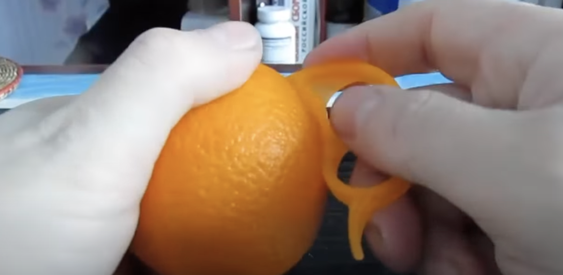 Eine Person benutzt einen Orangenschäler | Quelle: youtube.com/@zetira4582