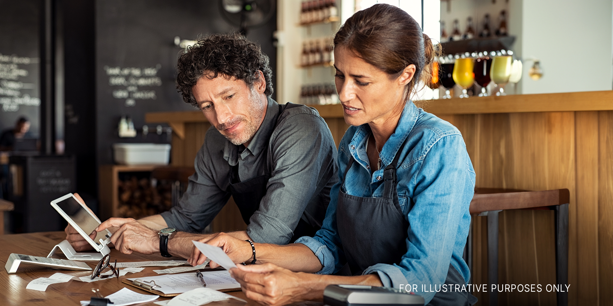 Ein Mann und eine Frau schauen gestresst, während sie Quittungen berechnen | Quelle: Shutterstock