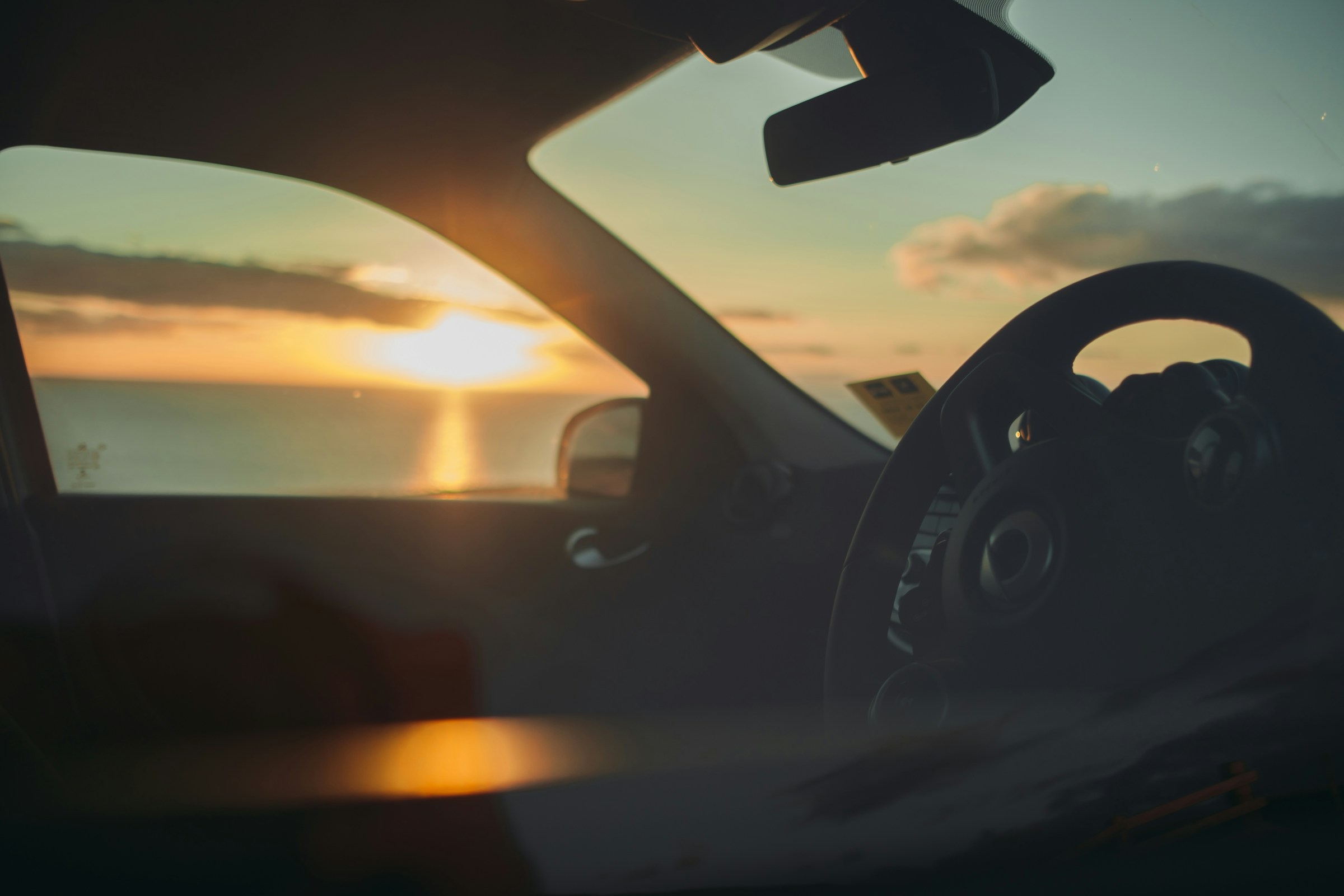 Ein Sonnenuntergang durch ein Autofenster | Quelle: Unsplash