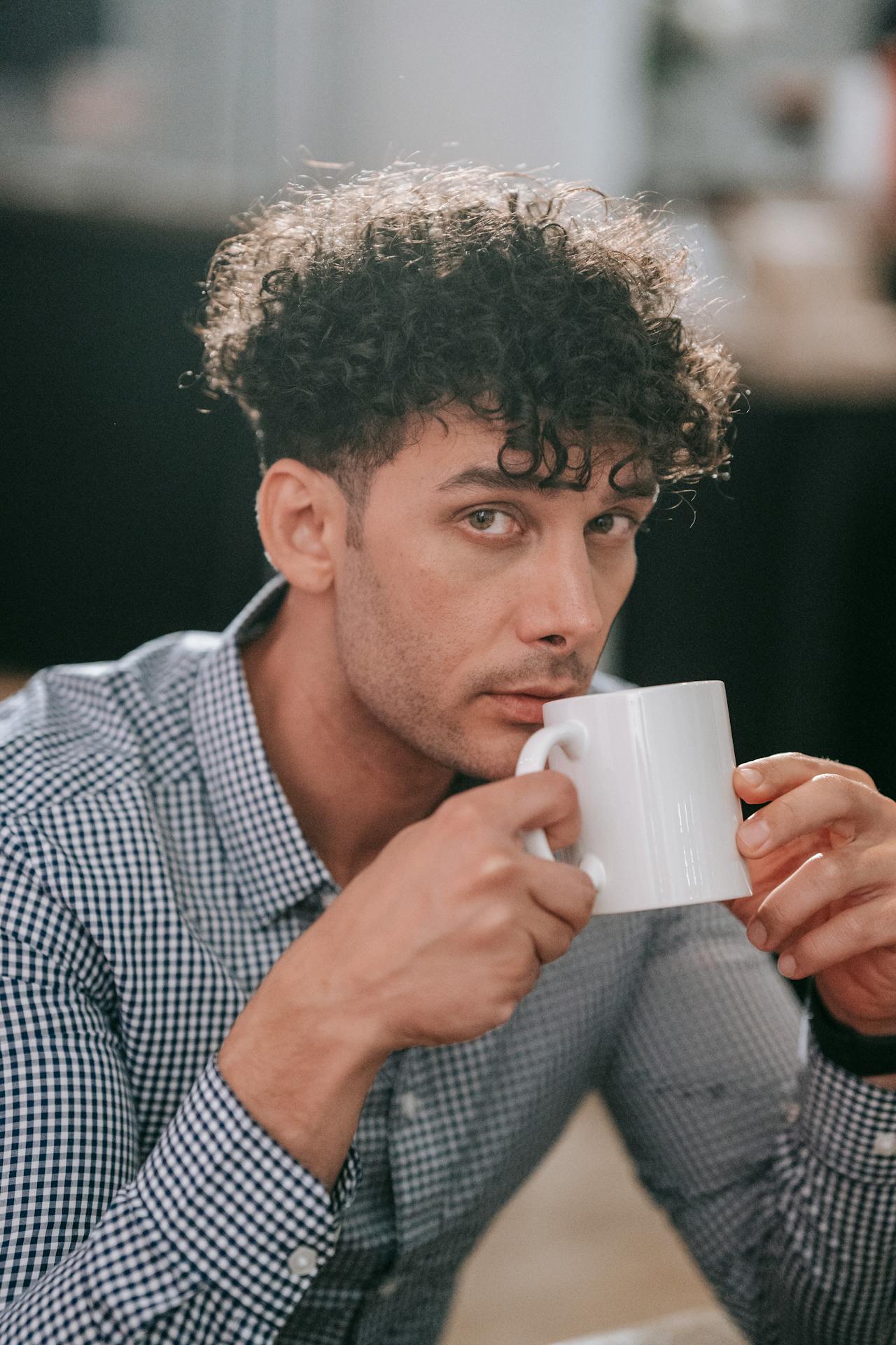 Ein Mann hält eine weiße Keramiktasse | Quelle: Pexels