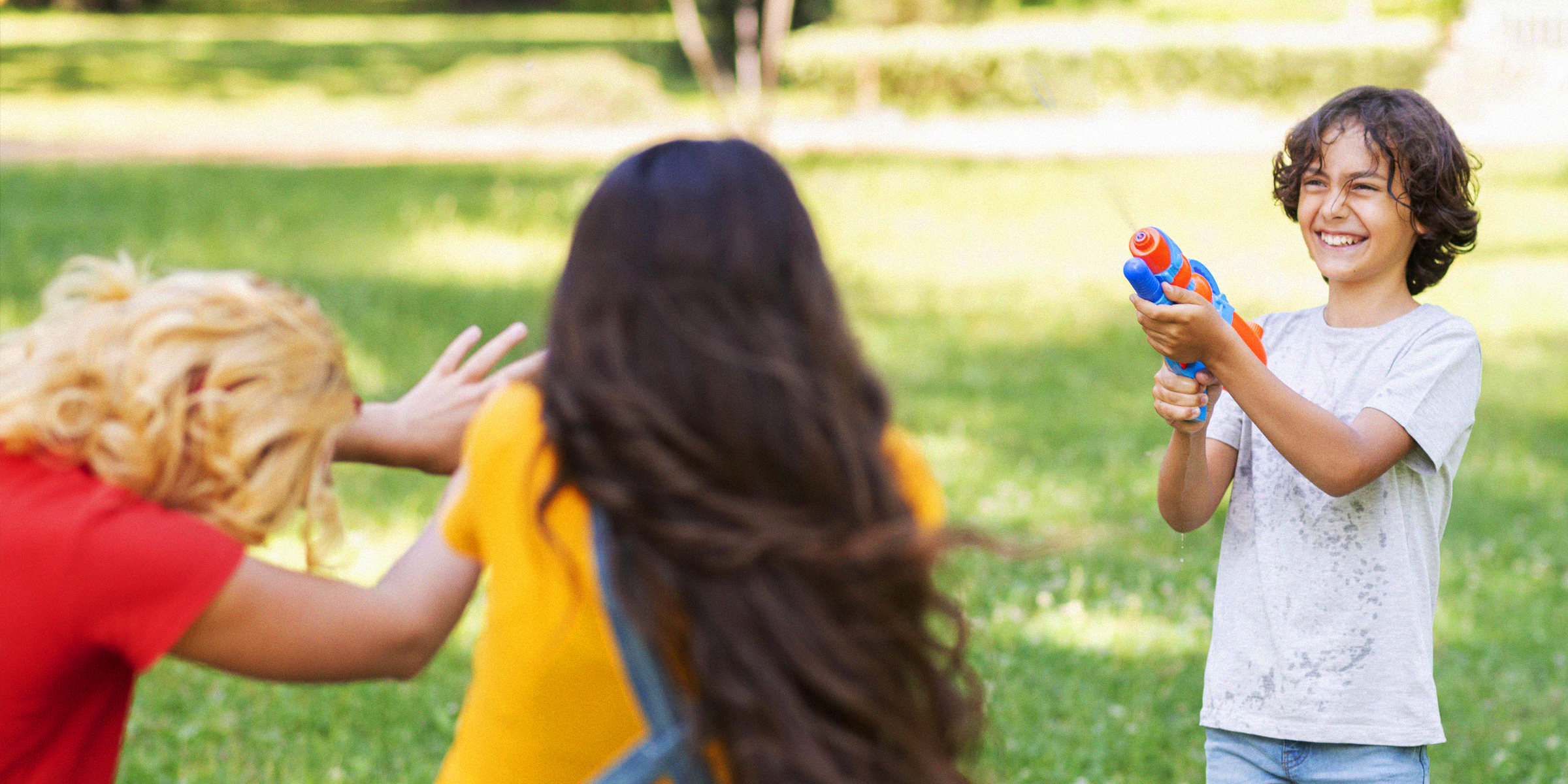 Kinder spielen mit einer Wasserpistole | Quelle: Freepik