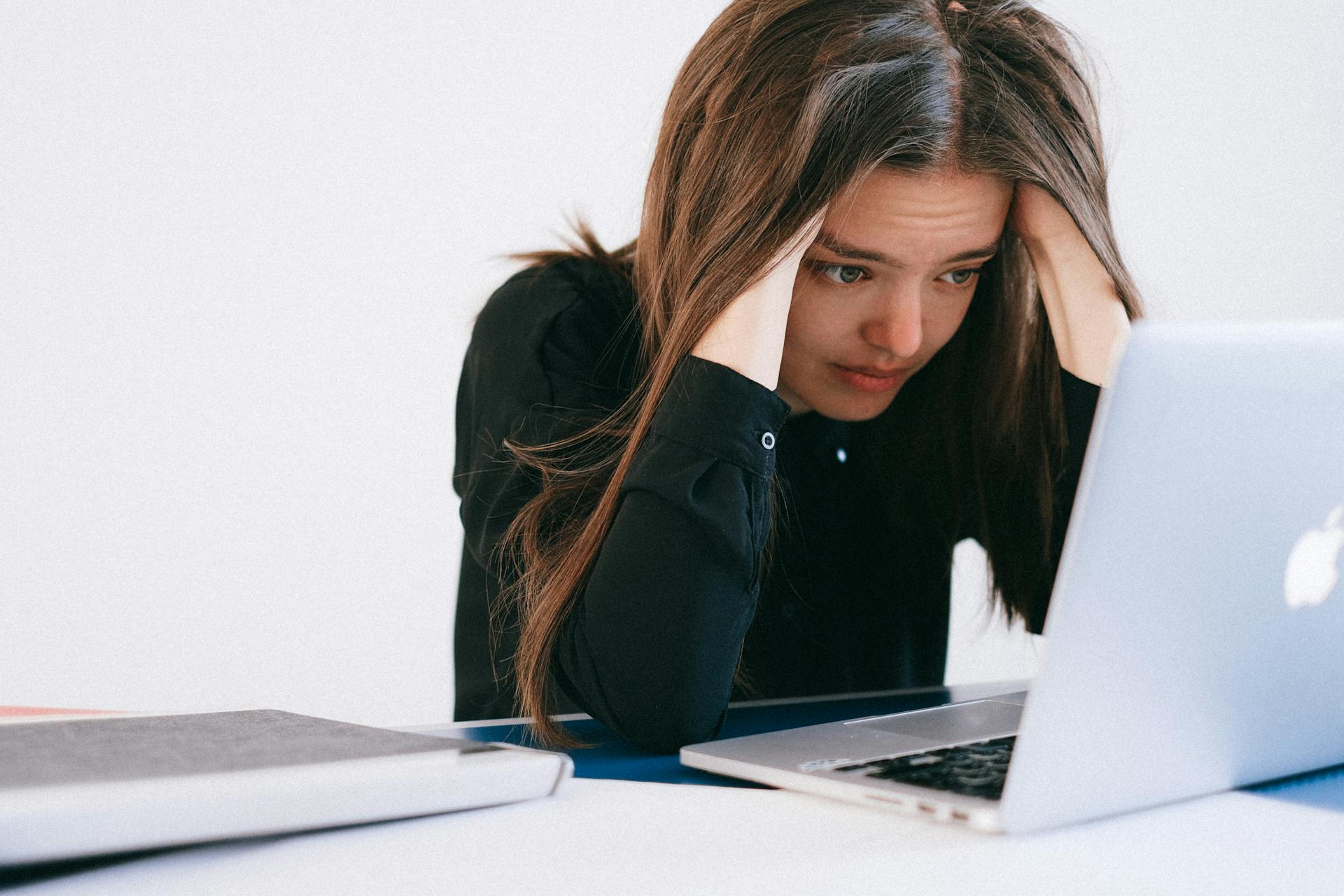 Eine traurige Frau schaut auf ihren Laptop | Quelle: Pexels