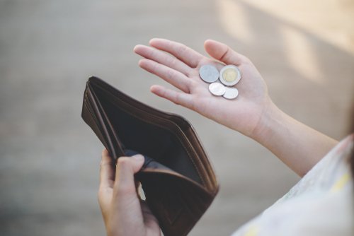 Frau zählt Münzen in ihrem Portemonnaie | Quelle: Shutterstock