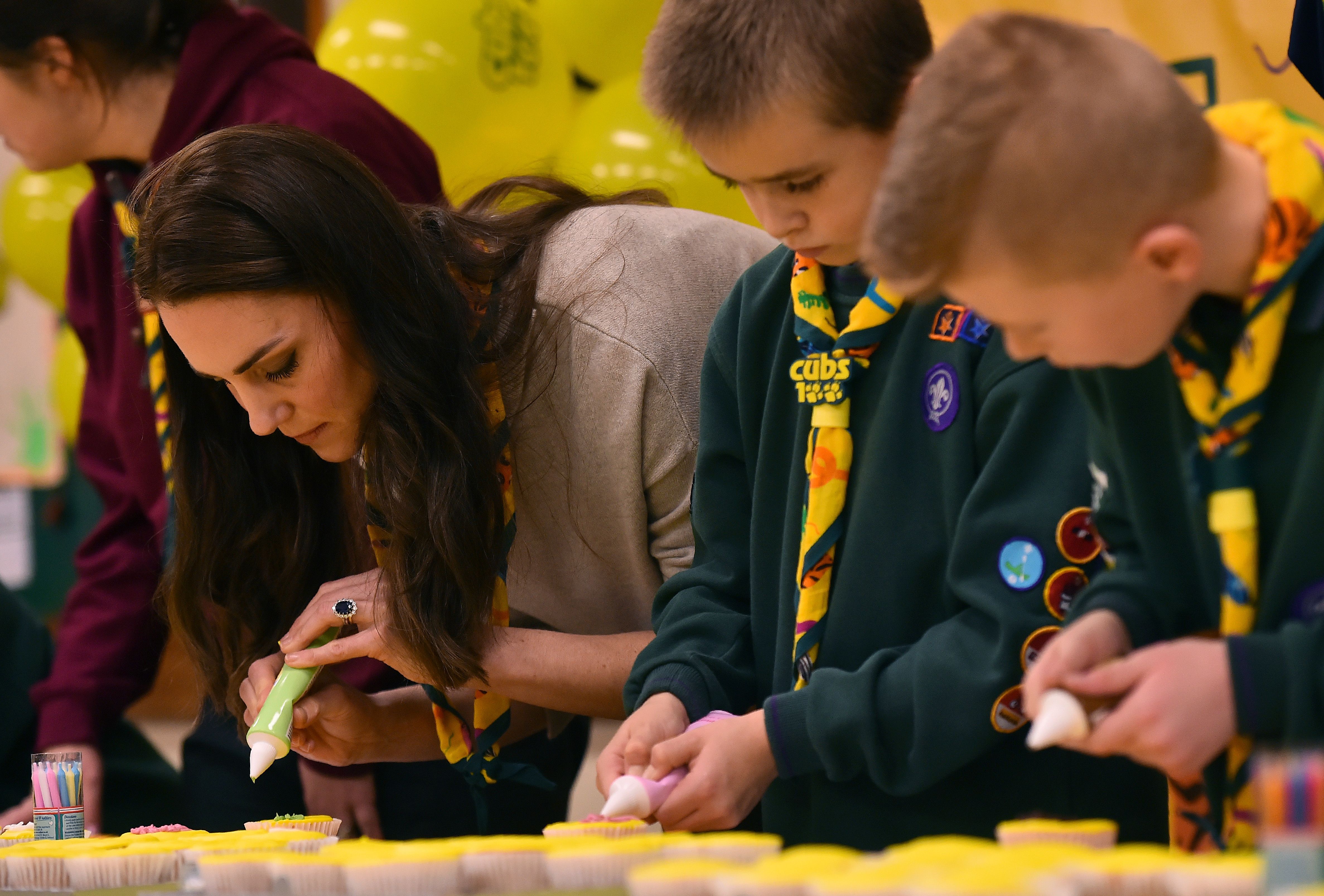 Kate Middleton glasiert einen Cupcake mit Mitgliedern des Cub Scout Packs während eines Cub Scout Pack-Treffens in Kings Lynn, Ostengland am 14. Dezember 2016 | Quelle: Getty Images