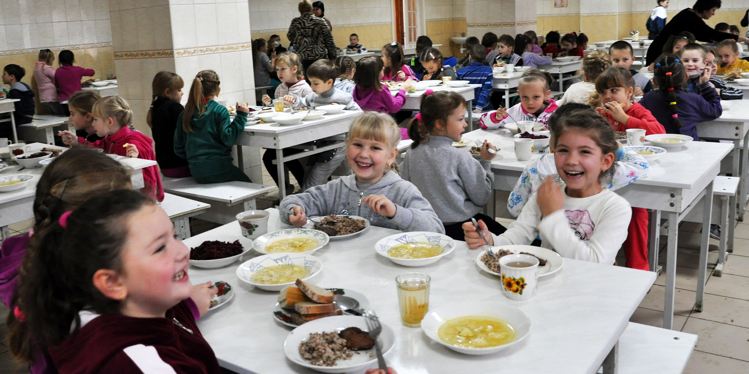 Kinder sitzen in einer Cafeteria | Quelle: Shutterstock