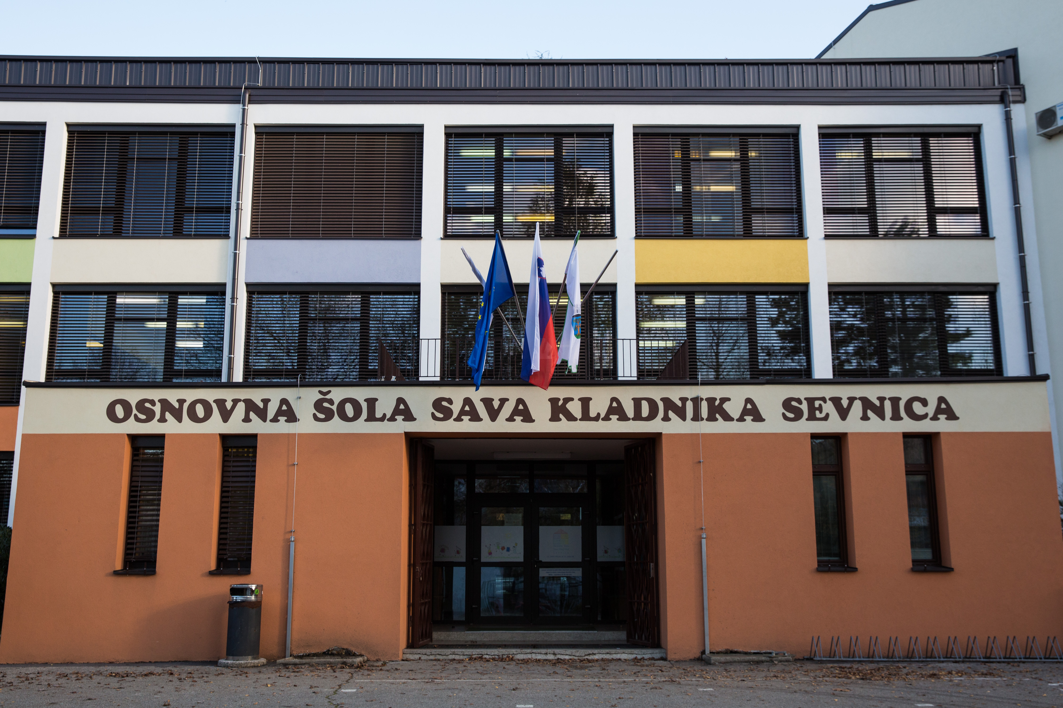 Der Eingang der „Osnovna šola Sava Kladnika Sevnica“, der Grundschule, die Melania Trump in ihrer Kindheit besuchte, wurde am 29. November 2016 in Sevnica, Slowenien, fotografiert. Das Gebäude hat eine ocker-weiße Fassade unter Reihen großer horizontaler Fenster, über dem markanten Schriftzug der Schule wehen die National- und Regionalflaggen. | Quelle: Getty Images