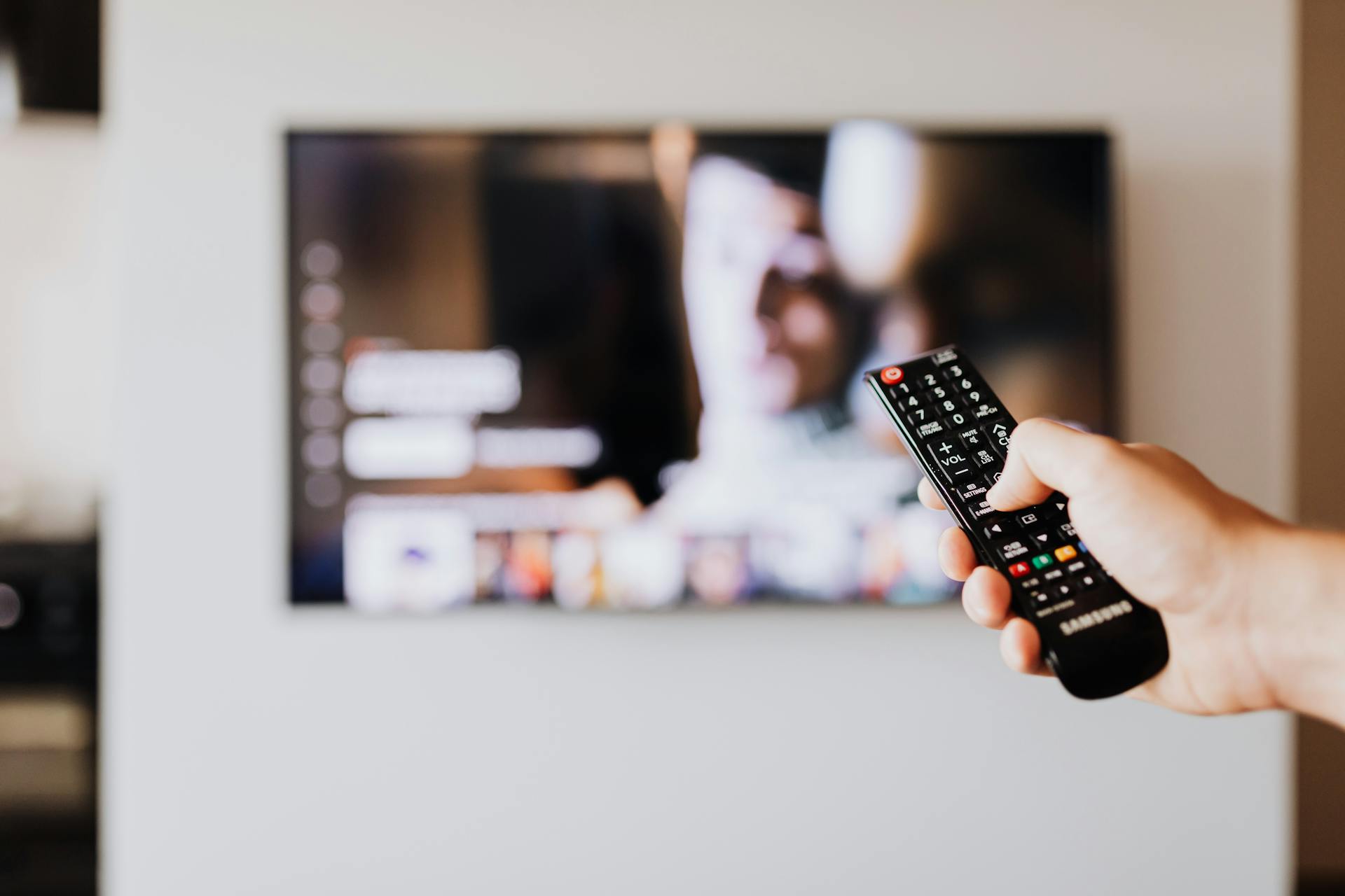 Ein Mann hält eine TV-Fernbedienung | Quelle: Pexels