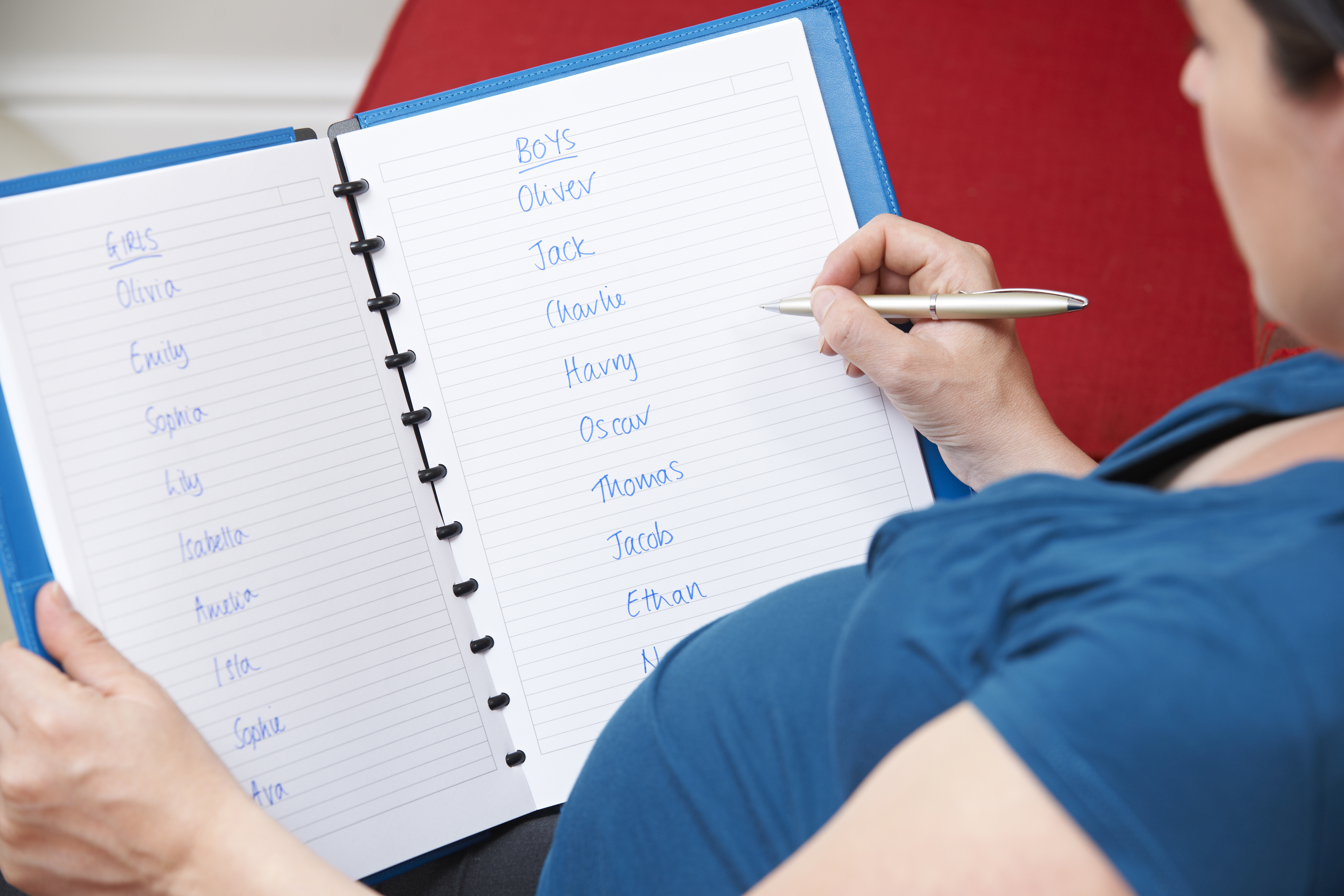 Eine schwangere Frau schreibt mögliche Babynamen auf | Quelle: Shutterstock
