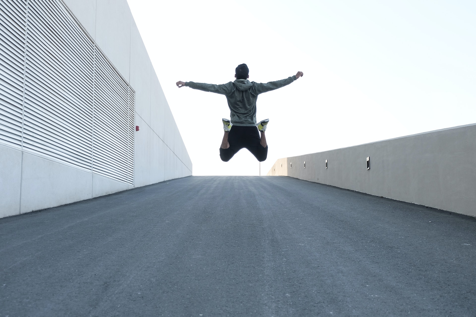 Ein Mann springt mit offenen Armen in die Luft | Quelle: Pexels