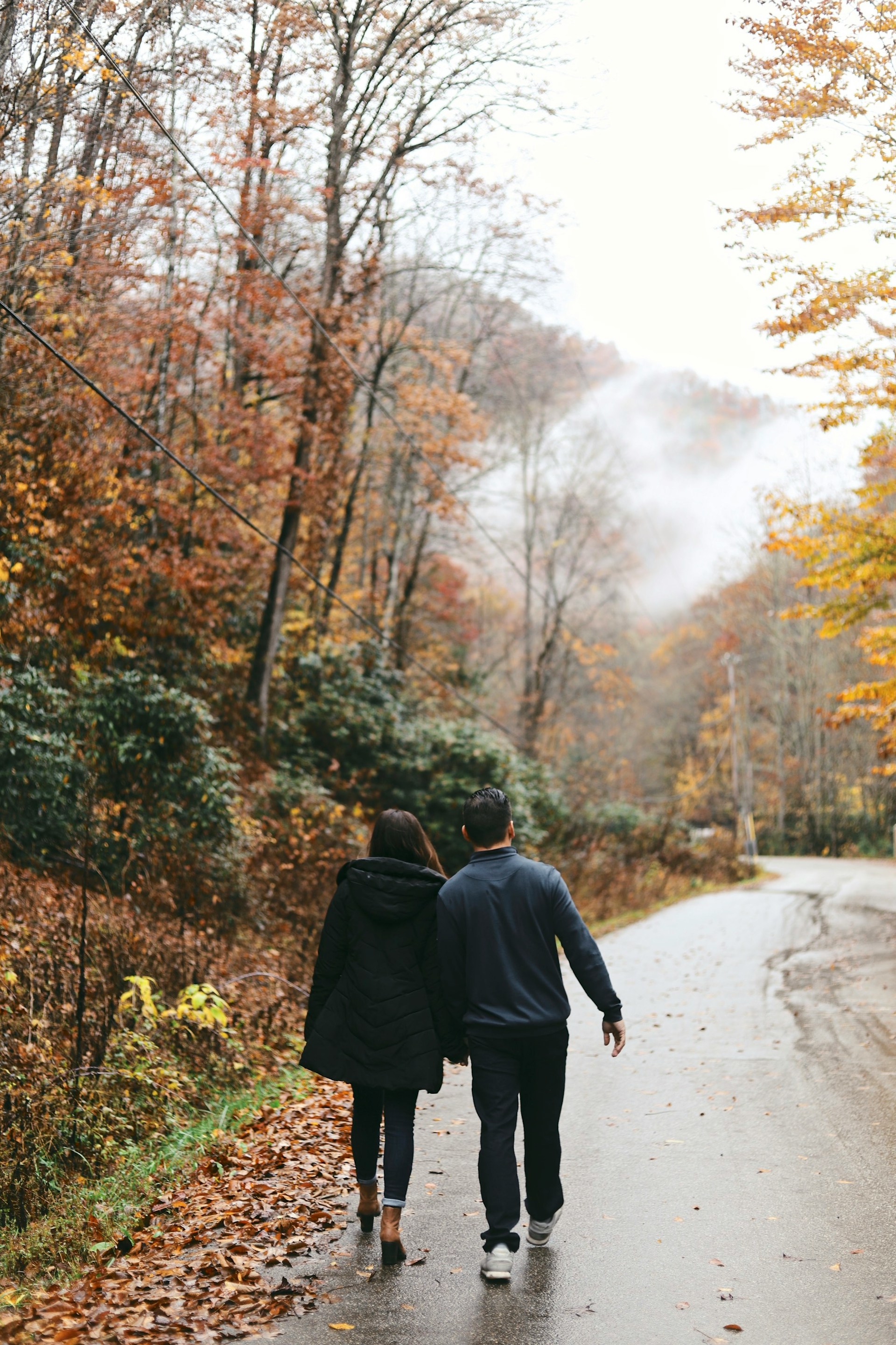 Ein Paar hält sich an den Händen und geht auf der Straße spazieren | Quelle: Unsplash