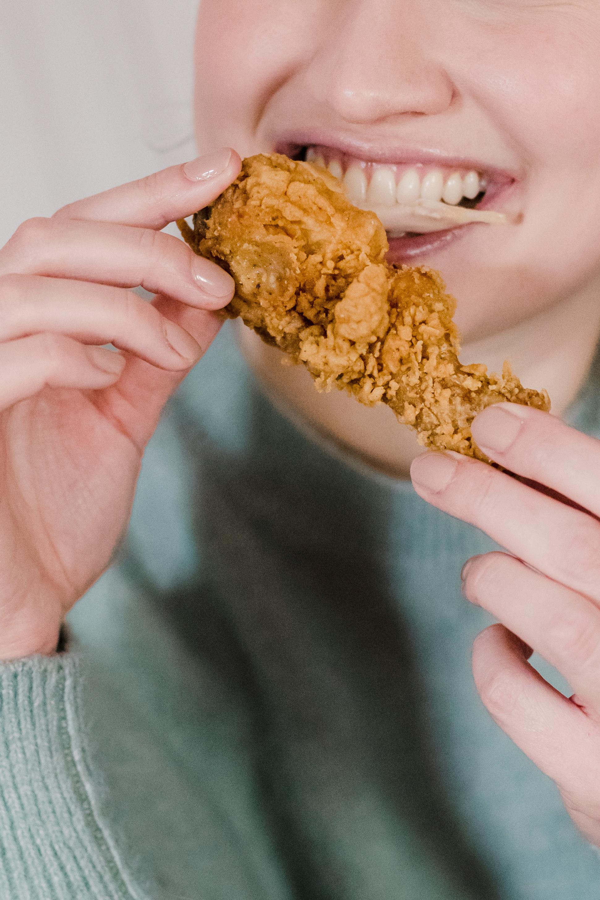 Eine Person isst Brathähnchen | Quelle: Pexels