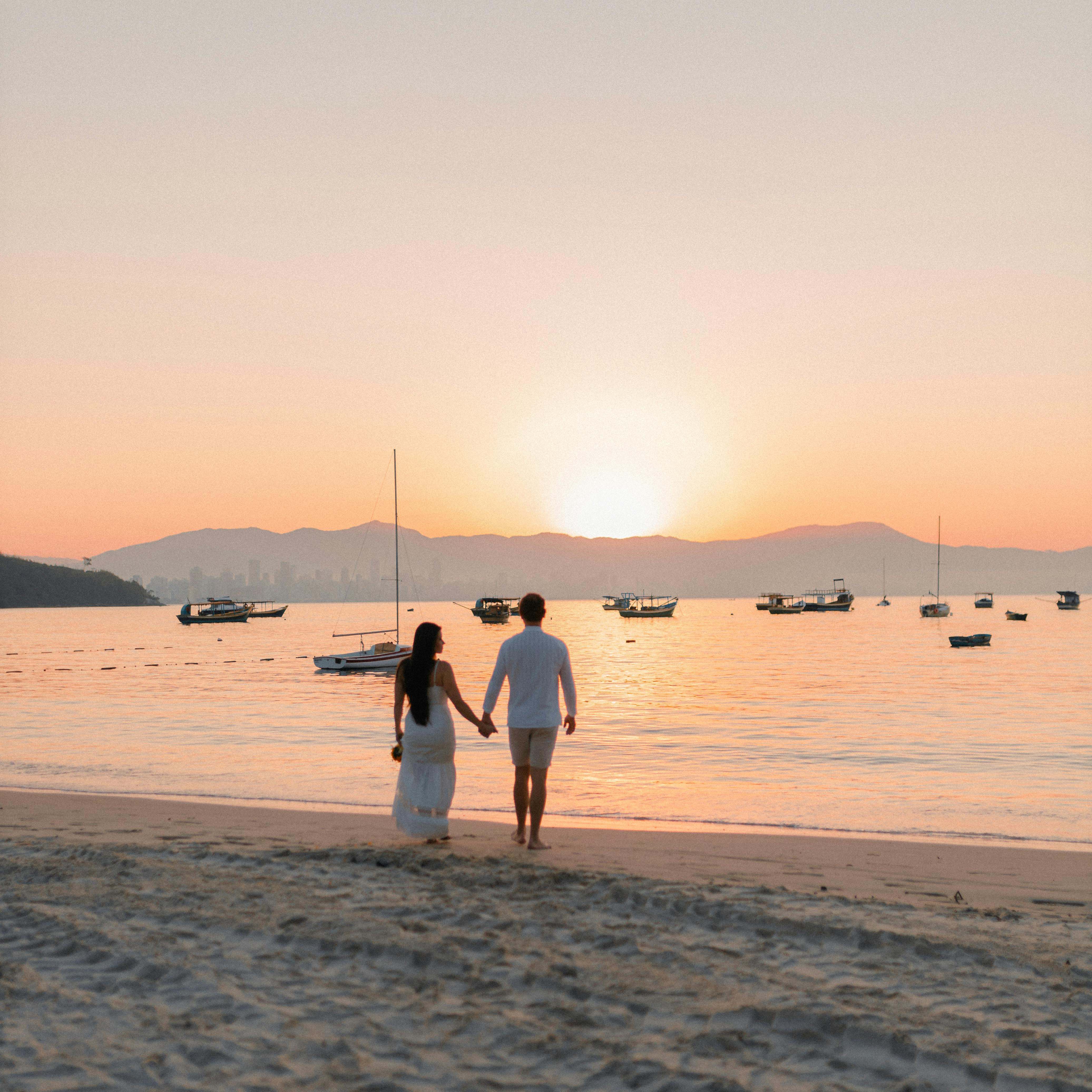 Ein Paar, das am Strand spazieren geht und sich an den Händen hält | Quelle: Pexels