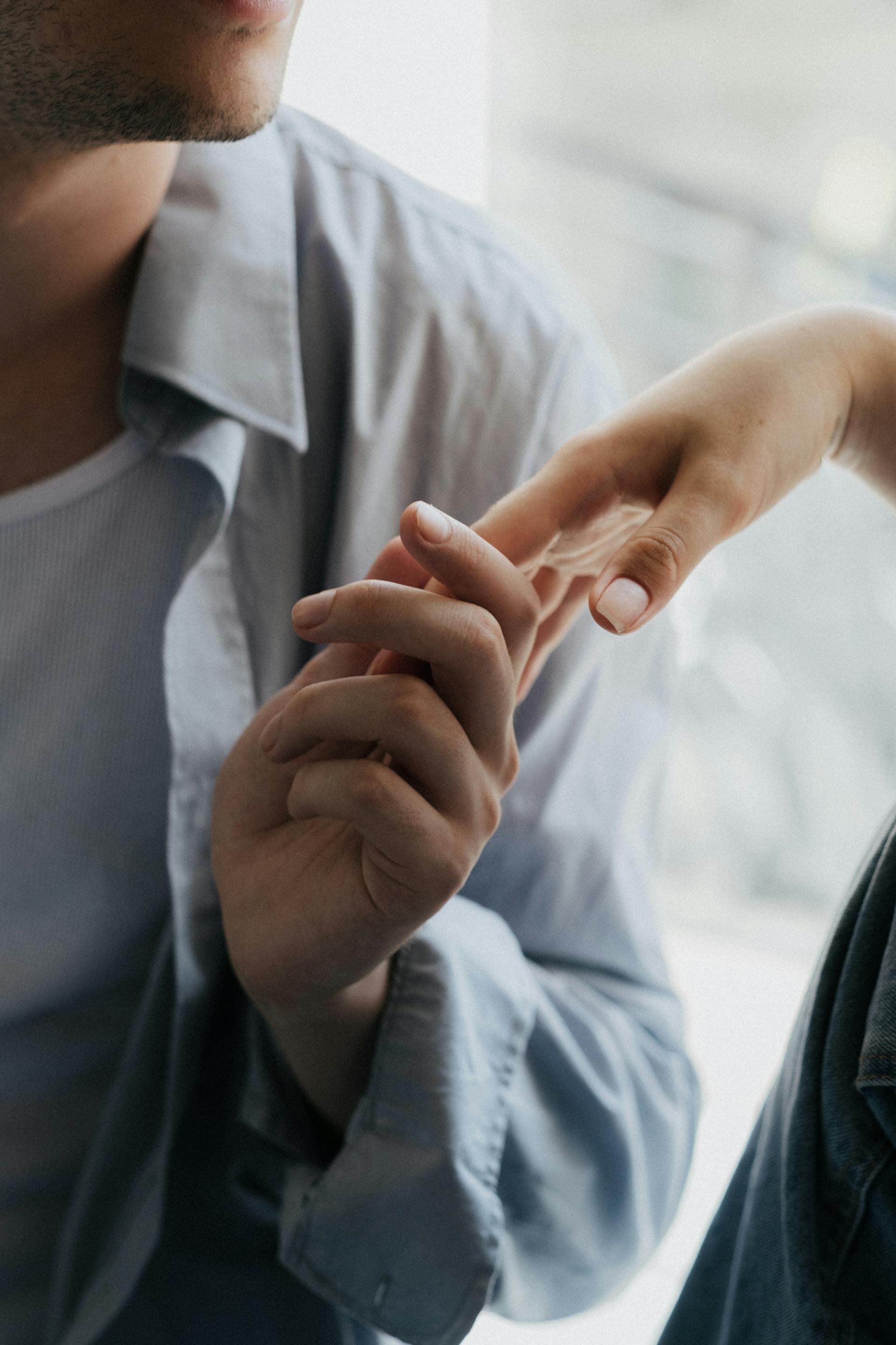 Ein Mann hält sanft die Hand einer Frau | Quelle: Pexels