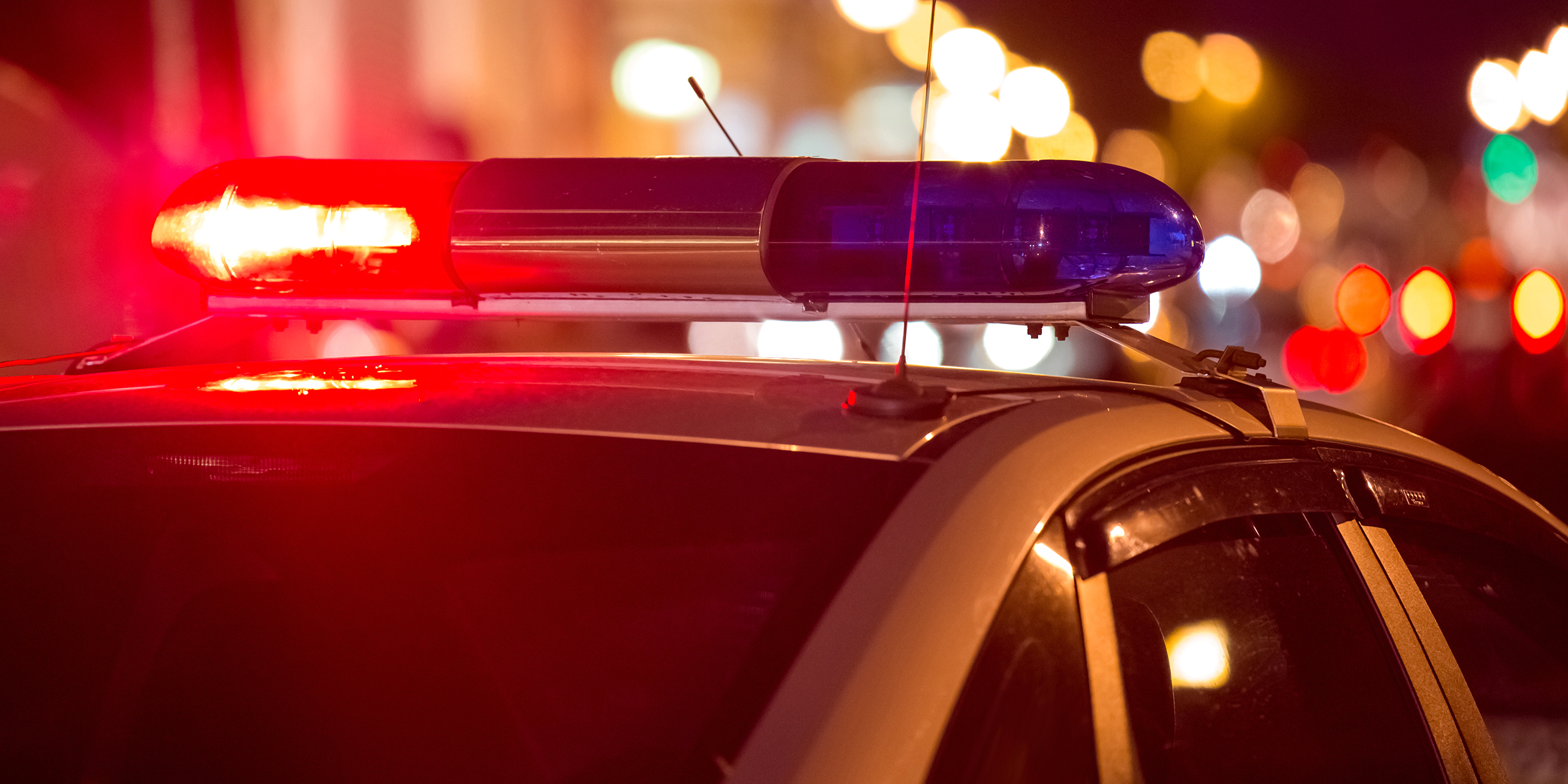 Ein Polizeiauto mit blinkenden roten und blauen Lichtern bei Nacht | Quelle: Shutterstock