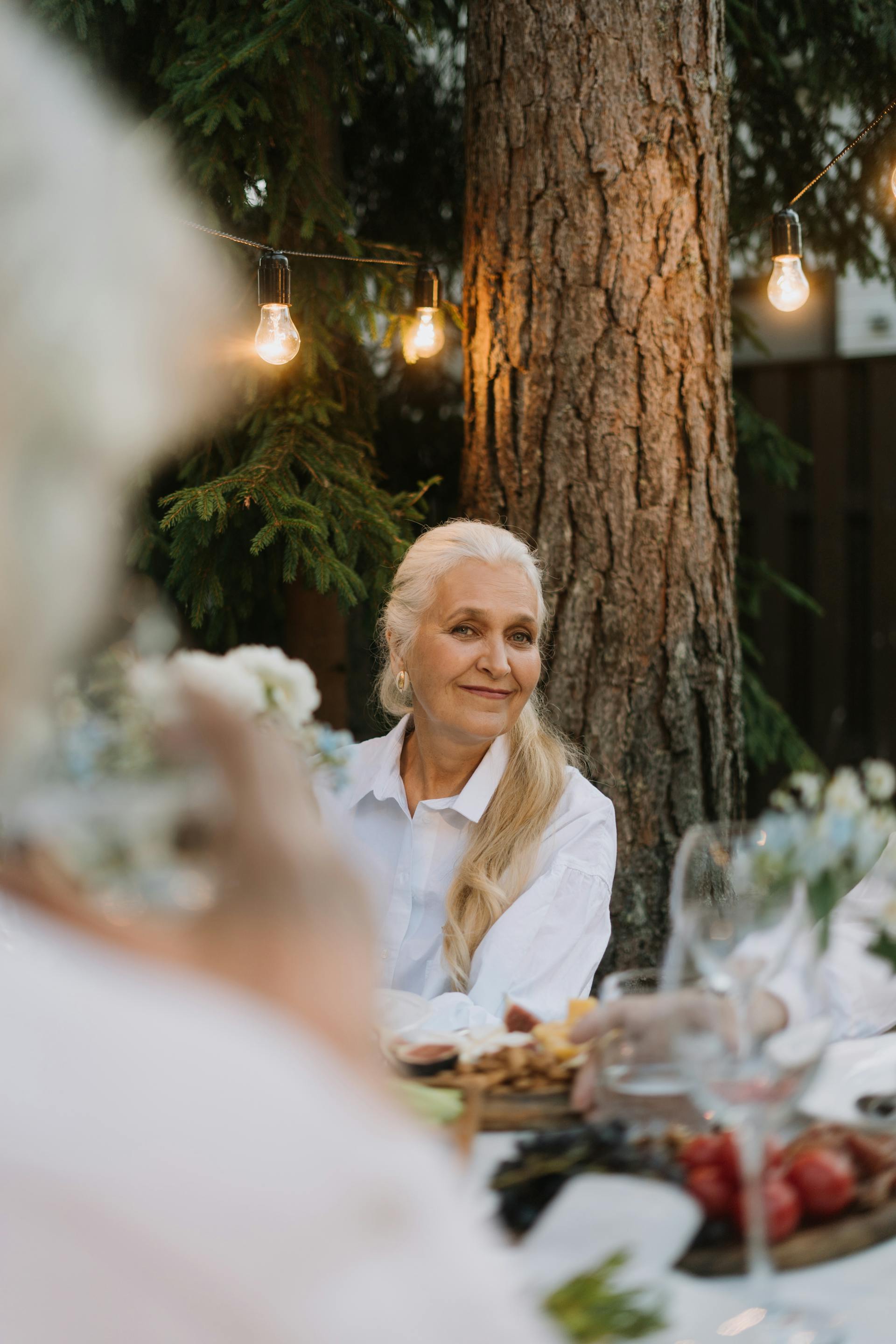 Eine reife Frau mit langen, blonden Haaren lächelt auf einer Party | Quelle: Pexels