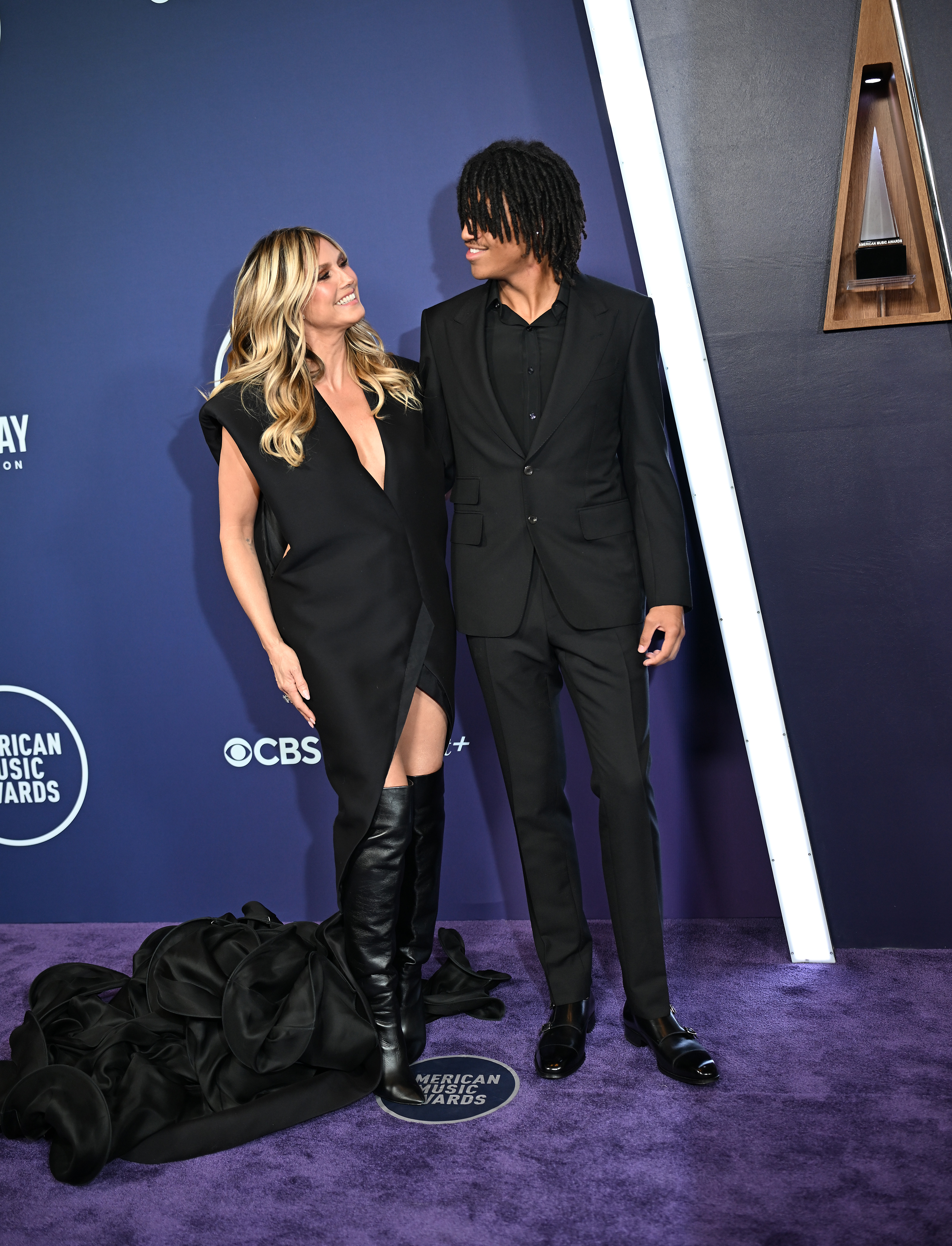 Heidi Klum teilt einen warmen Moment mit ihrem Sohn Henry Samuel, als sie auf dem roten Teppich der AMAs ein Lächeln austauschen – ihre dramatische Schleppe bündelte sich neben seinem scharfen schwarzen Anzug.