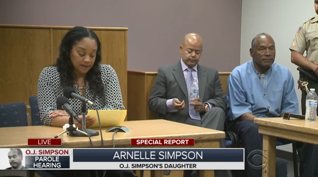 Arnelle Simpson spricht vor dem Bewährungsausschuss, während O.J. Simpson in der Ecke des Raumes während einer Anhörung des Bewährungsausschusses 2017 in Nevada zuhört. | Quelle: YouTube/CBSNewYork