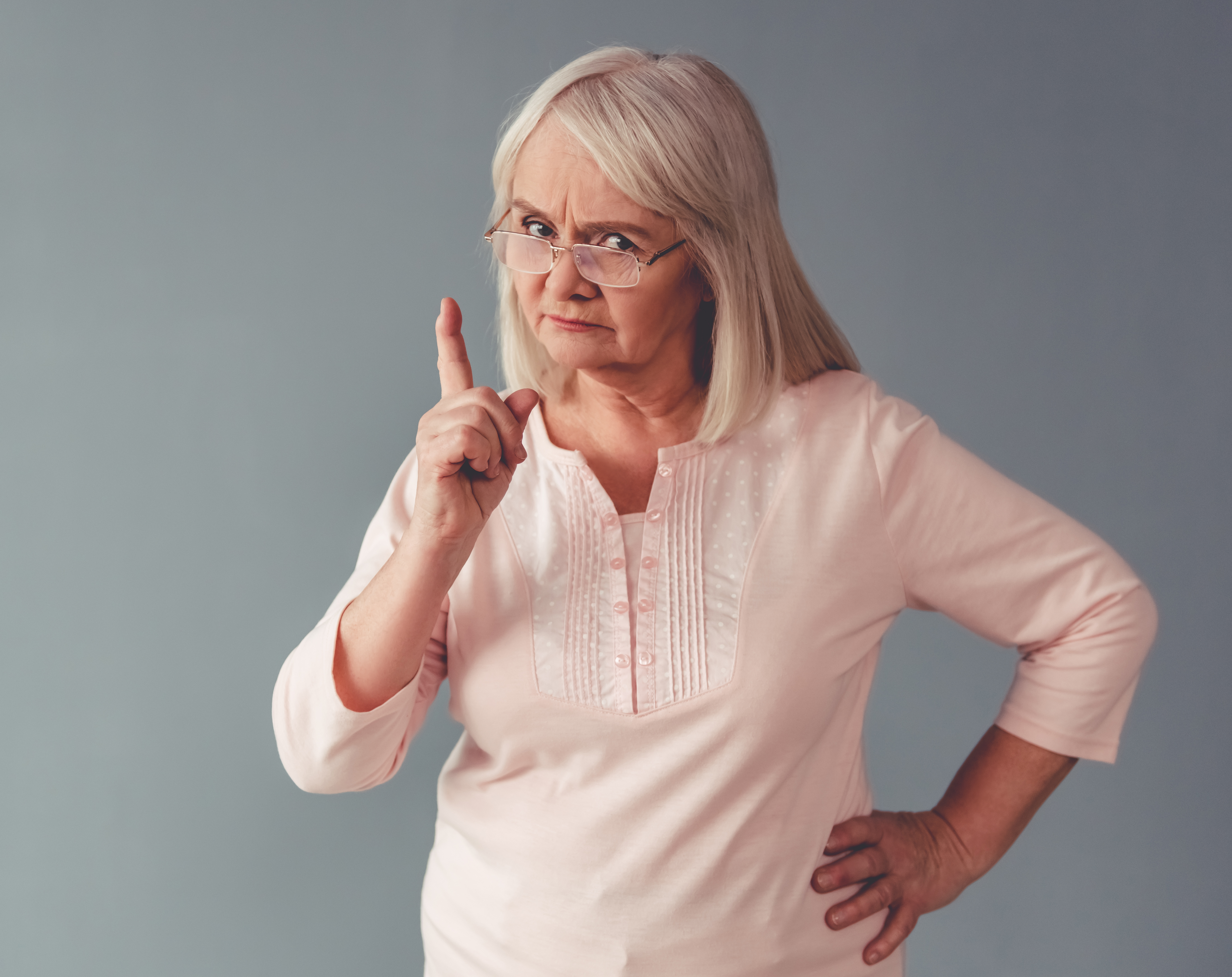 Eine wütende ältere Frau warnt mit ihrem Finger | Quelle: Shutterstock