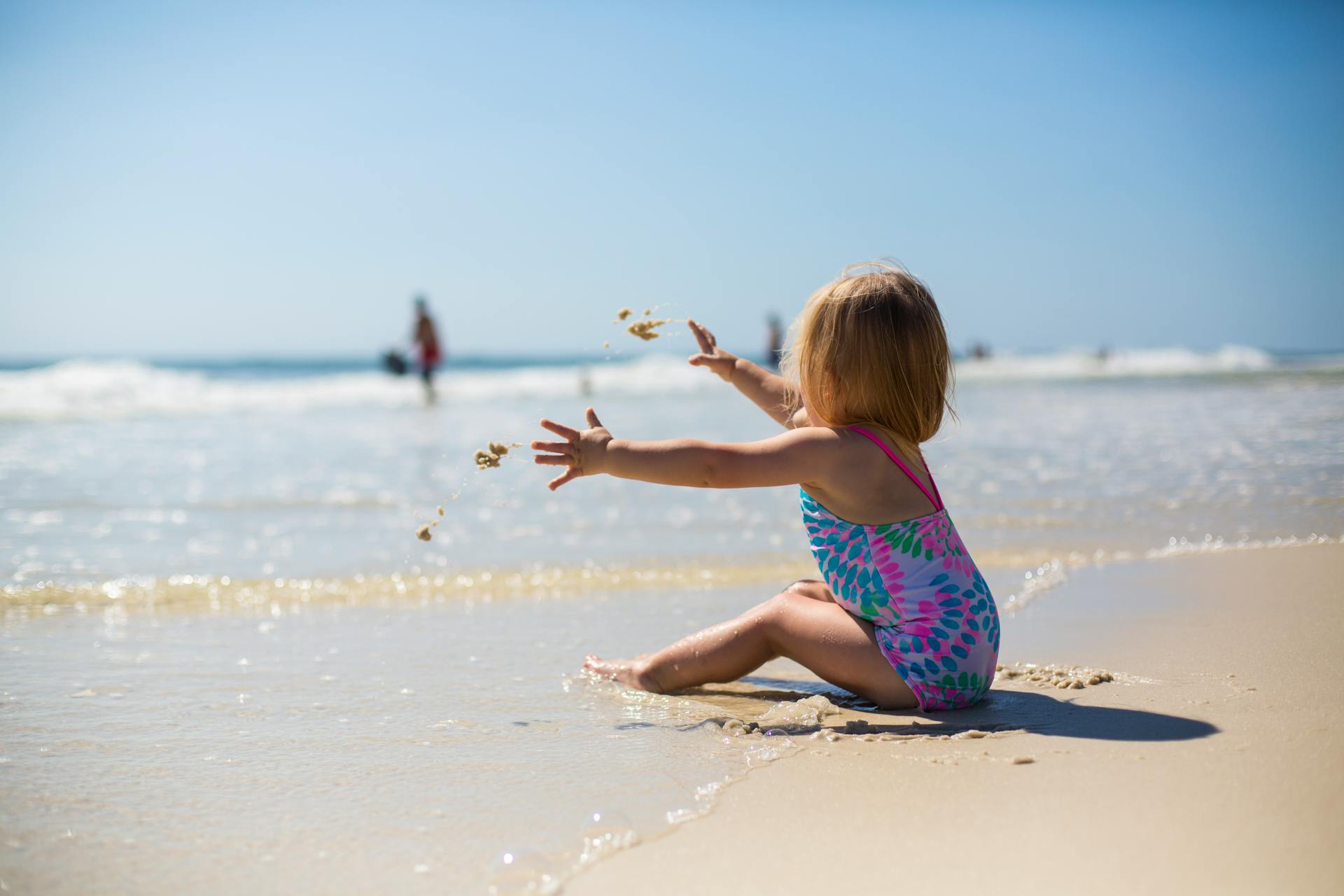 Ein Mädchen wirft Sand am Strand | Quelle: Pexels