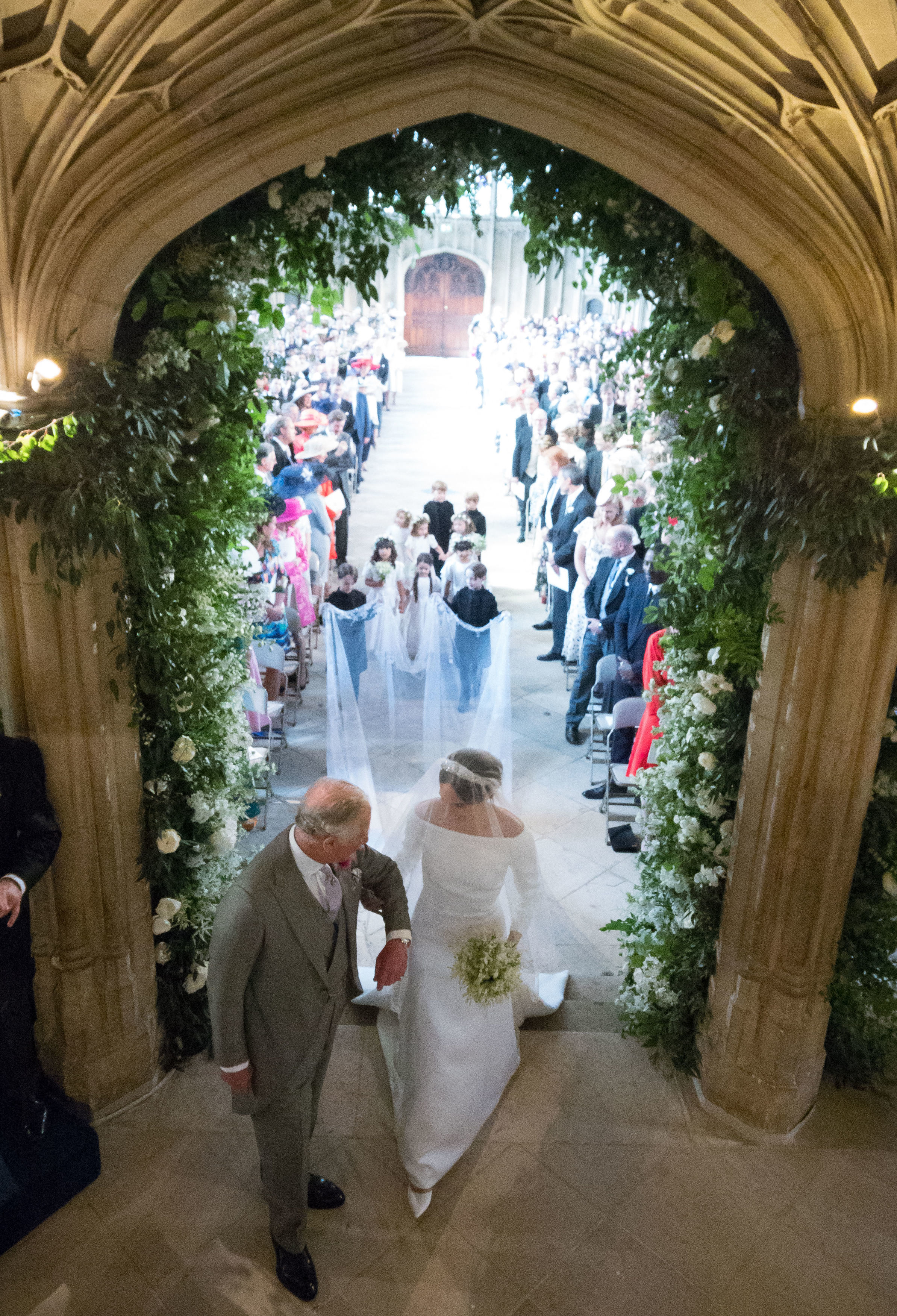 König Charles III. führt Meghan Markle in der St. George's Chapel am 19. Mai 2018 in Windsor, England, zum Altar. | Quelle:  Getty Images