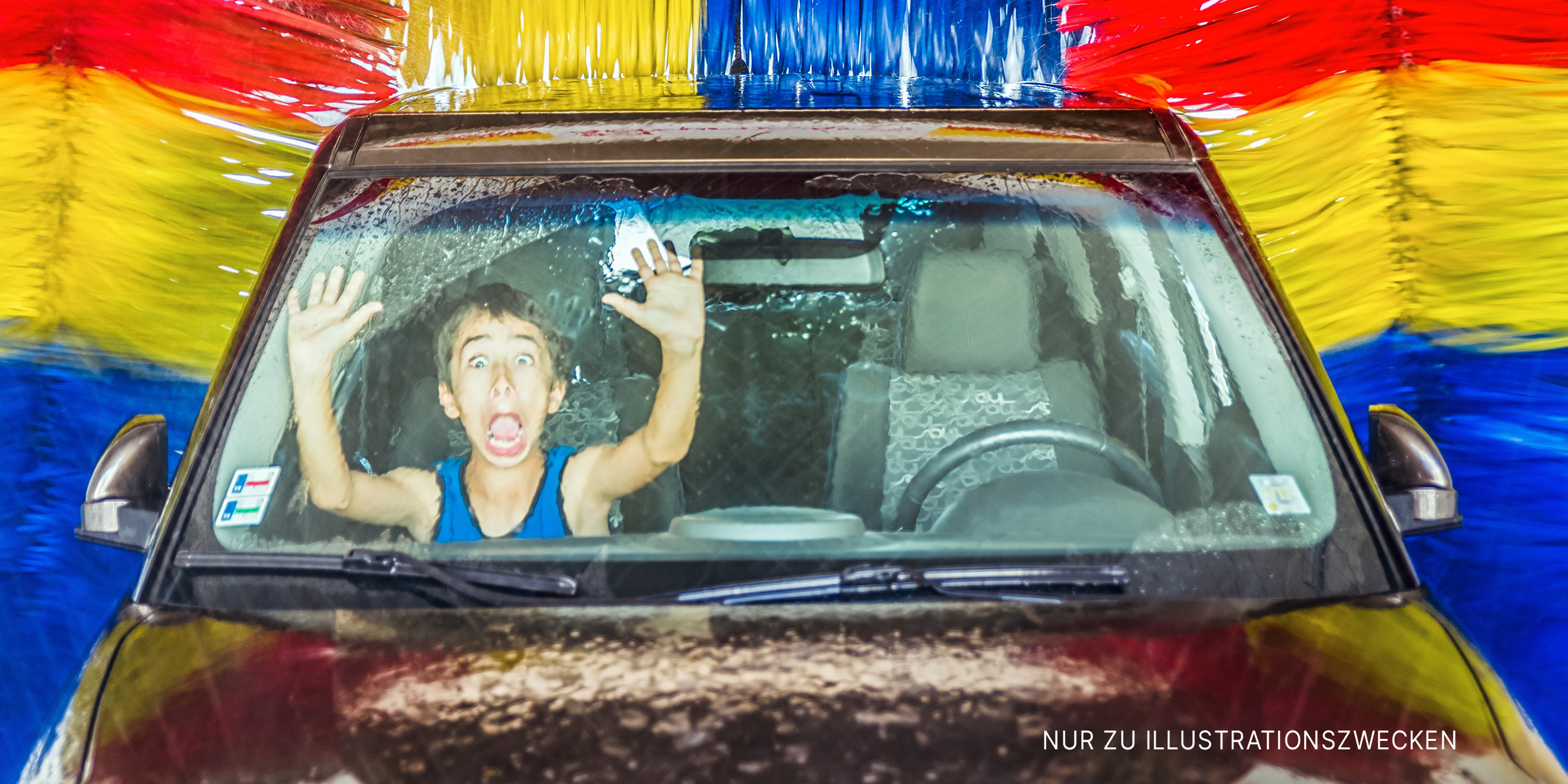 Junge in einem Auto in einer automatischen Autowaschanlage | Quelle: Shutterstock