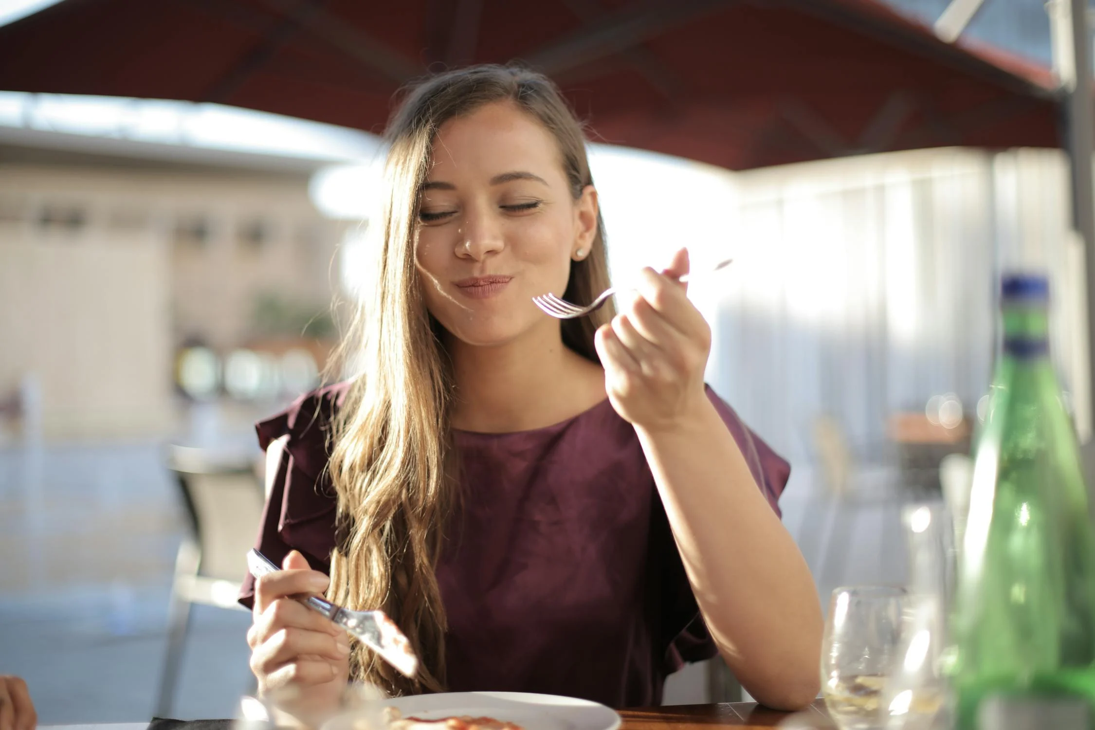 Eine lächelnde Frau beim Essen in einem Café | Quelle: Pexels