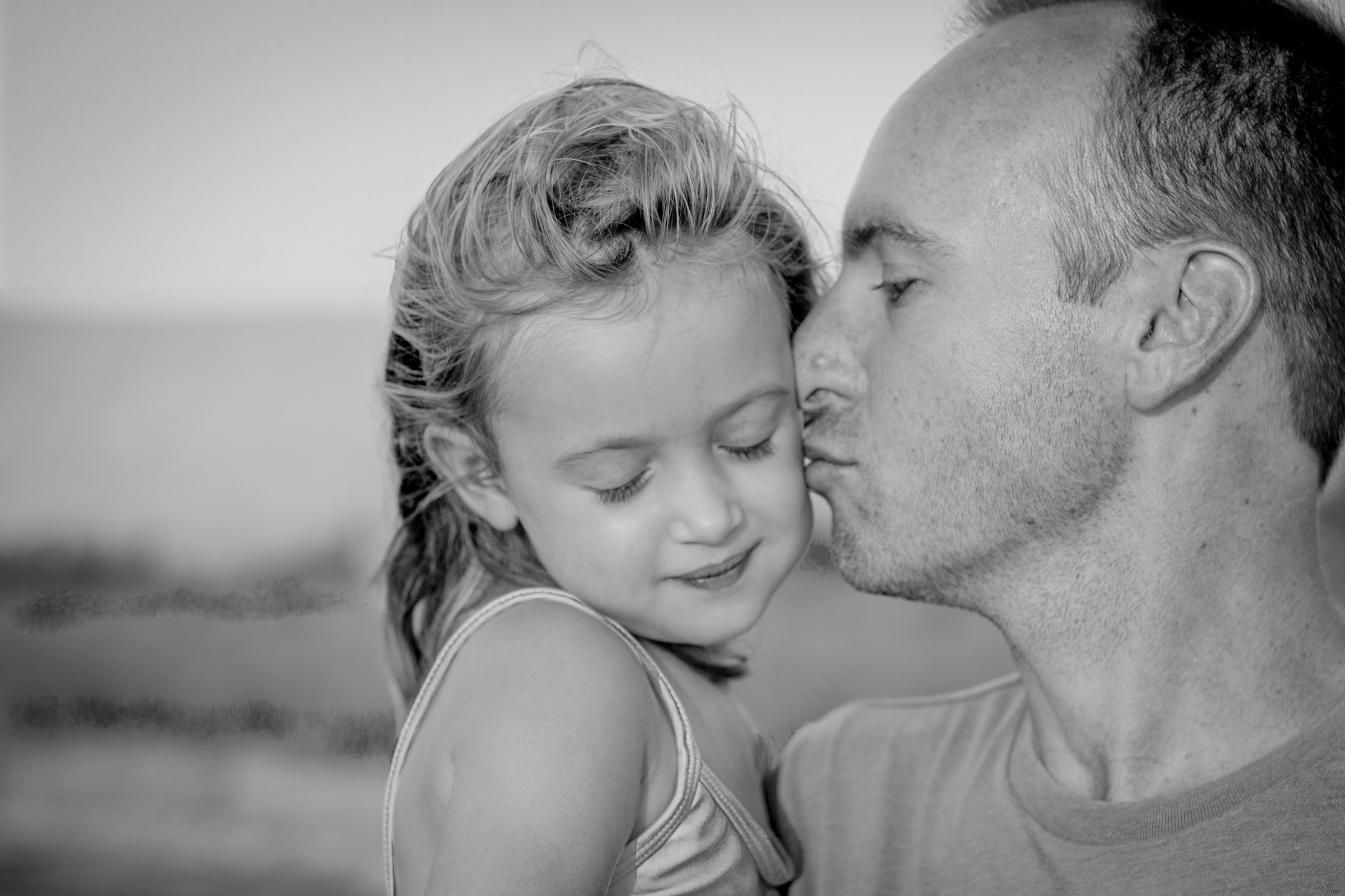 Vater küsst seine Tochter auf die Wange | Quelle: Unsplash