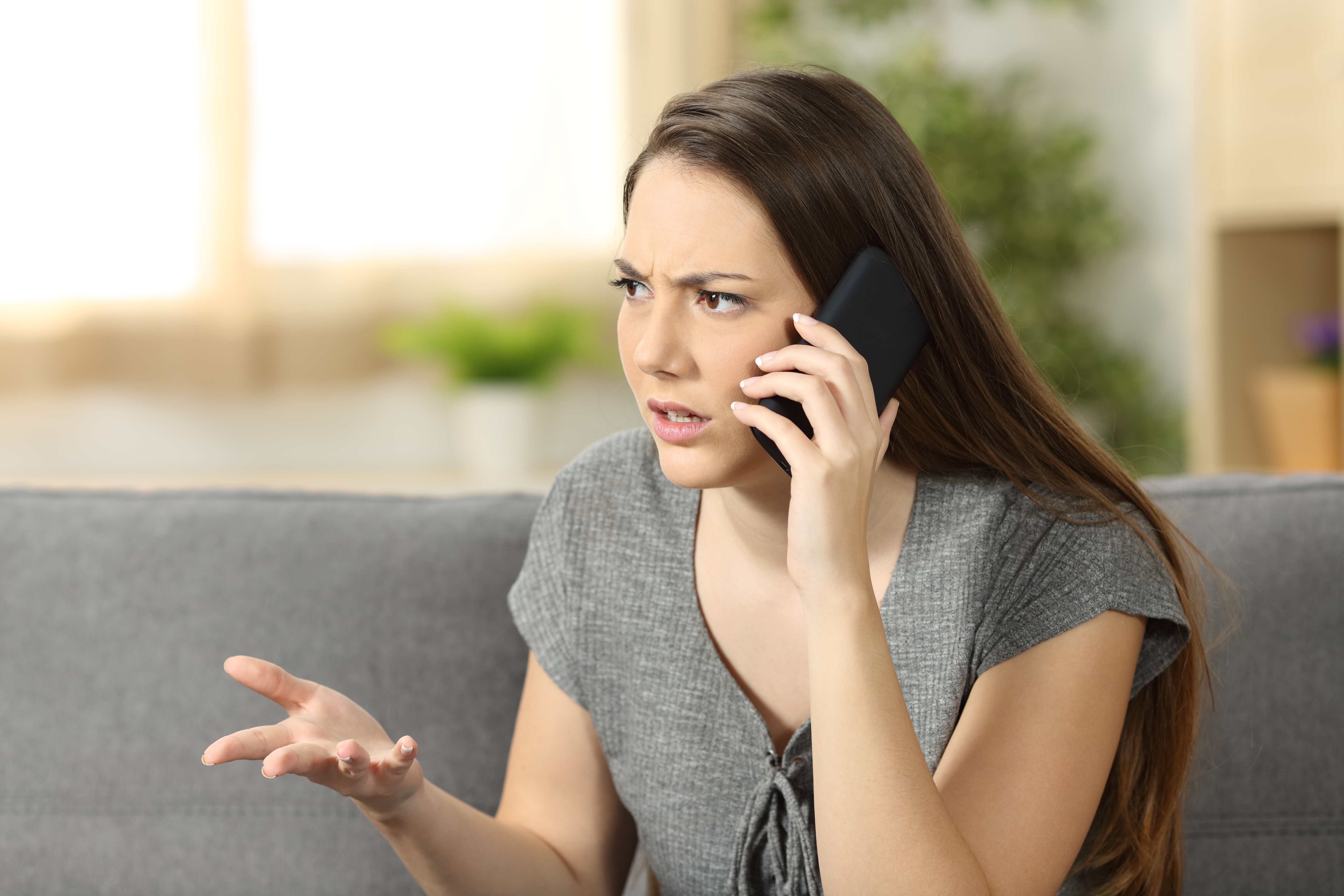 Eine wütende Frau, die in ihr Telefon spricht | Quelle: Shutterstock
