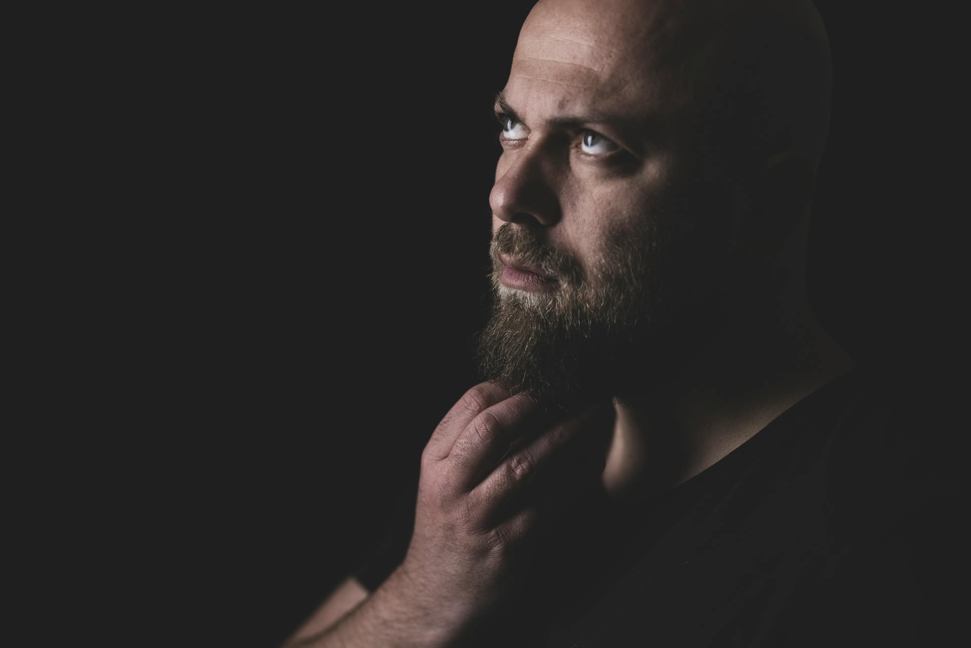 Ein Mann kratzt sich nachdenklich an seinem Bart | Quelle: Pexels