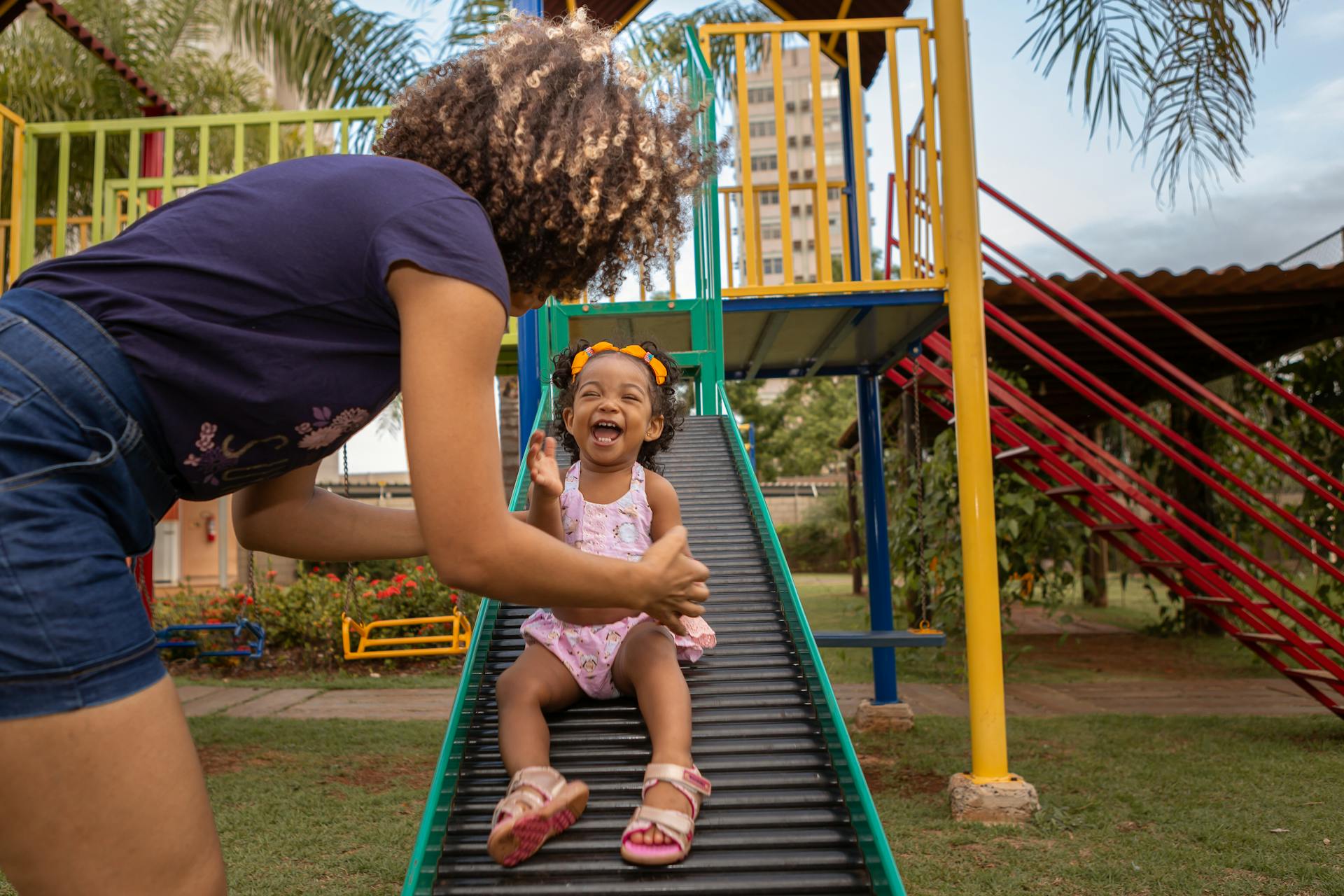 Eine Frau auf dem Spielplatz mit ihrem Kind | Quelle: Pexels