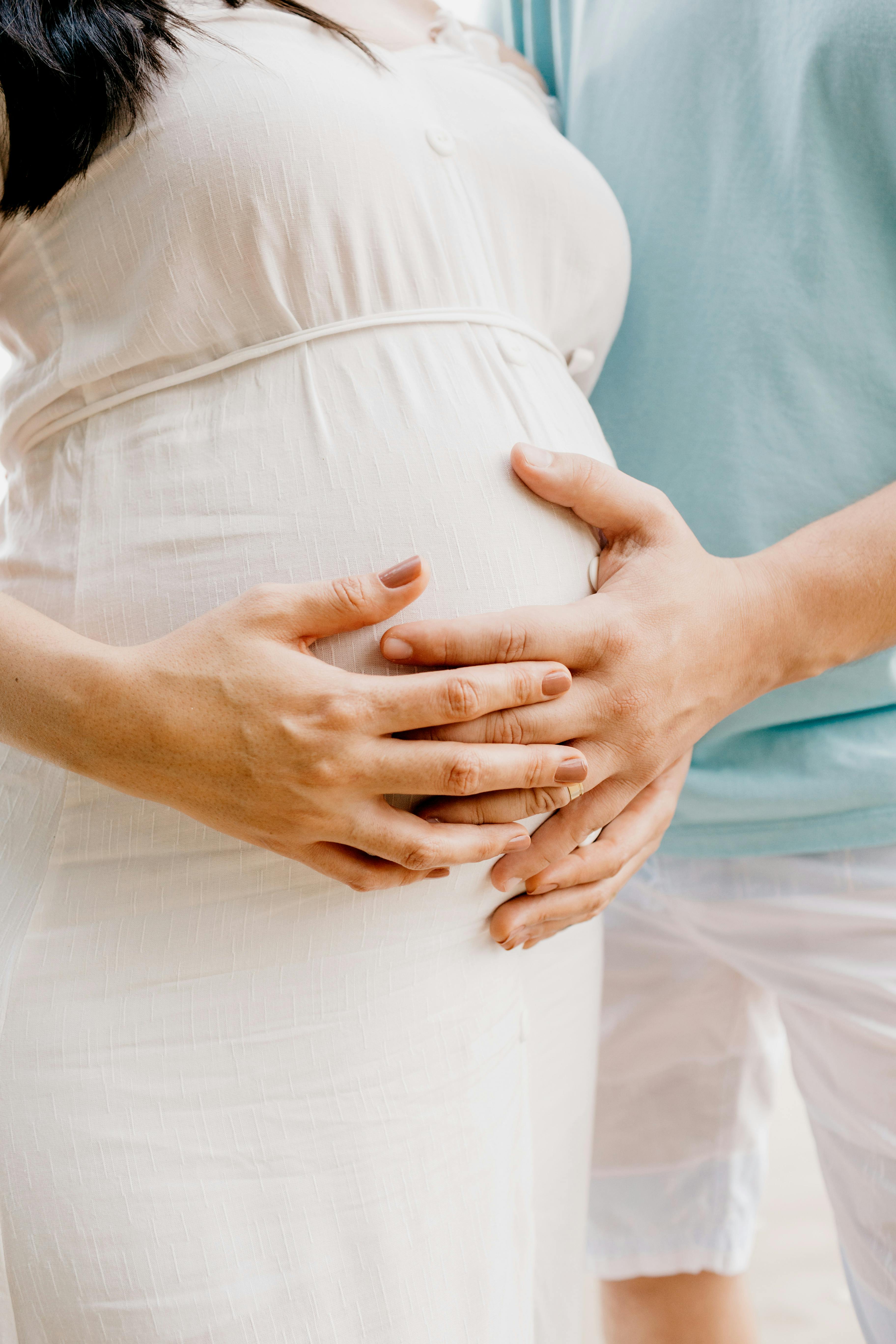 Ein Paar, das den Bauch einer schwangeren Frau hält | Quelle: Pexels
