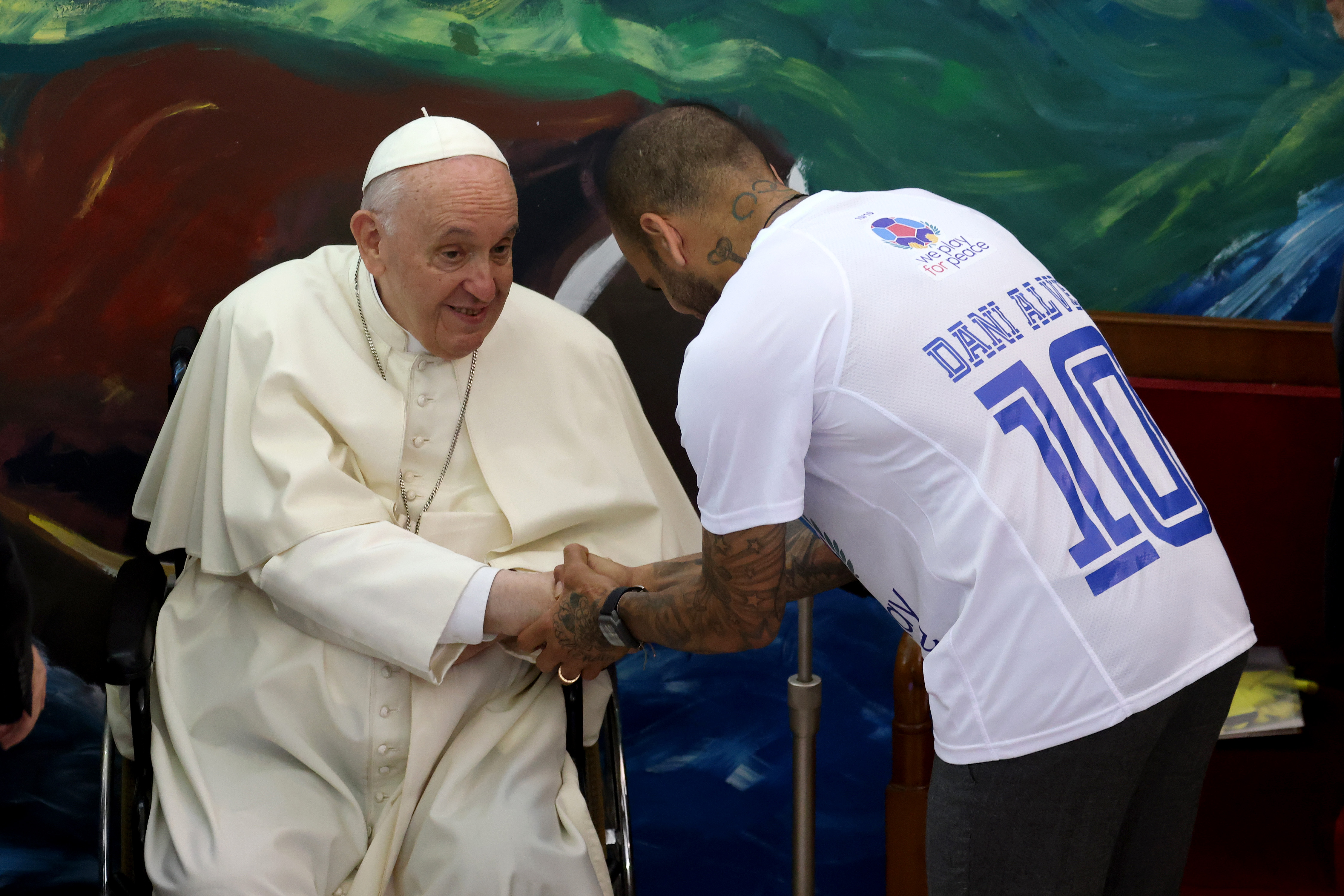 Papst Franziskus begrüßt den Fußballspieler Dani Alves bei der Vorstellung der internationalen Bewegung Scholas Occurrentes in der Päpstlichen Universität Urban in Vatikanstadt, Vatikan, am 19. Mai 2022. | Quelle: Getty Images