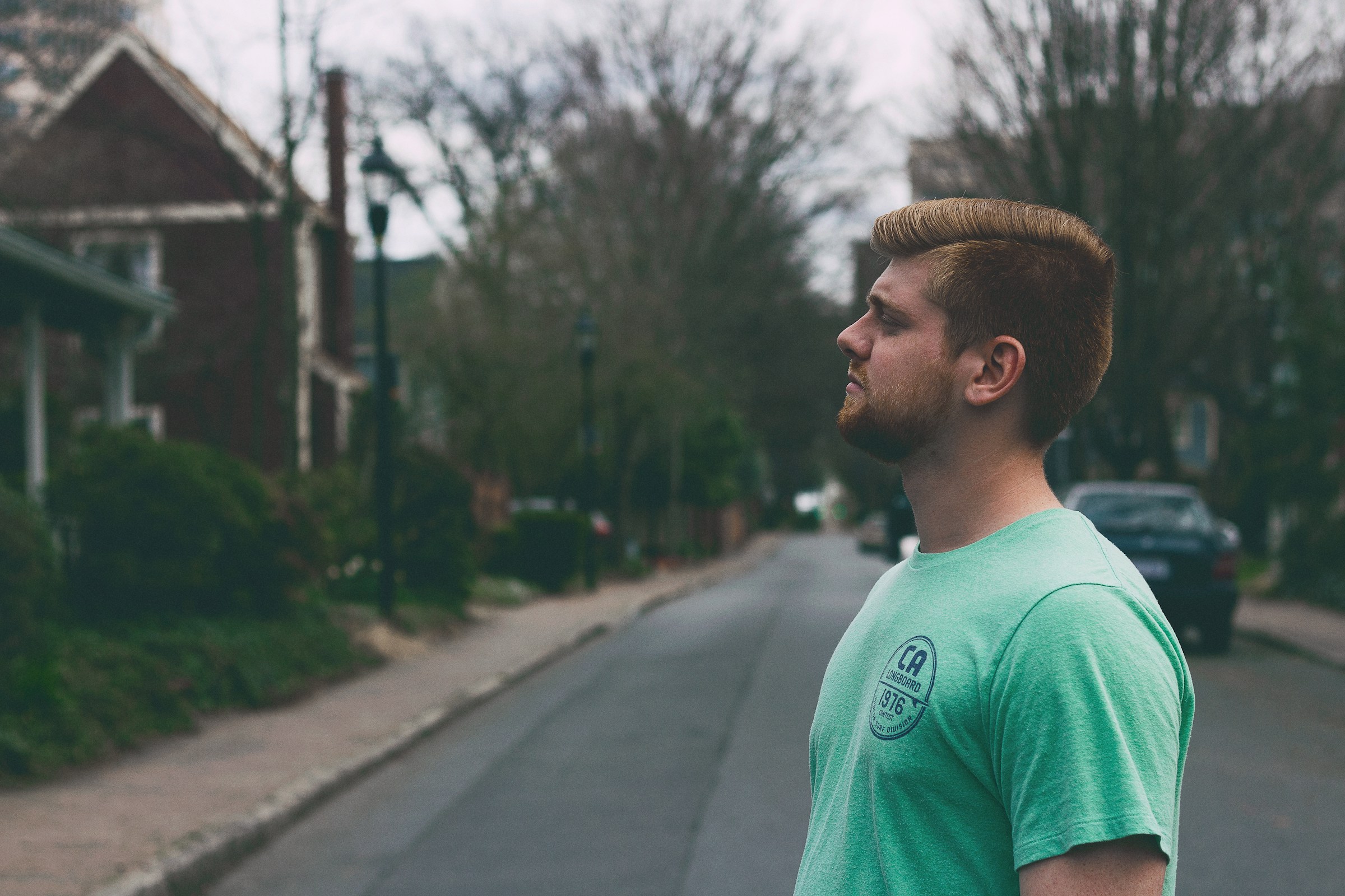 Ein Mann in einem grünen T-Shirt vor einem Haus während des Tages | Quelle: Unsplash