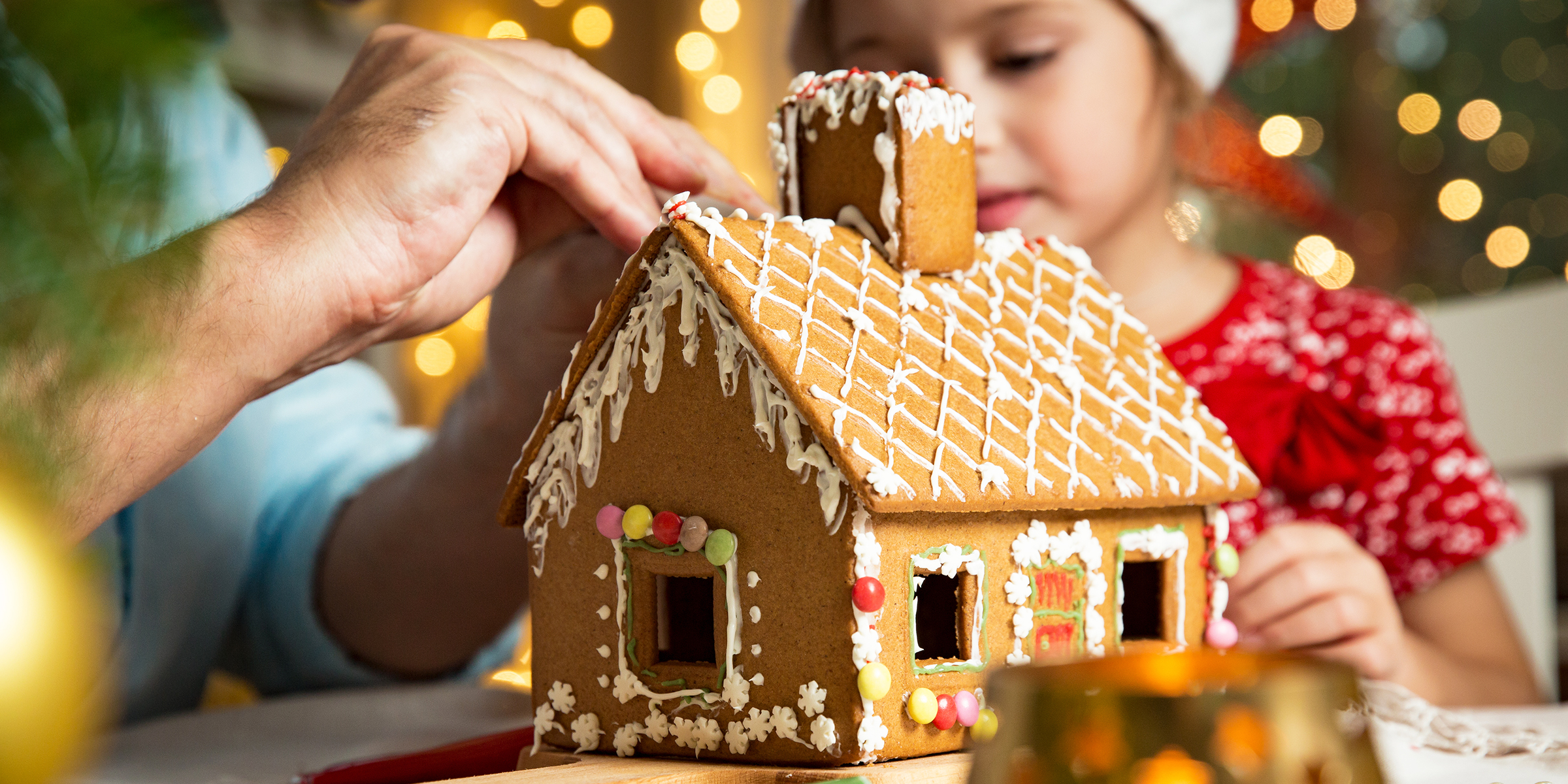 Ein kleines Mädchen mit einem Pfefferkuchenhaus | Quelle: Shutterstock