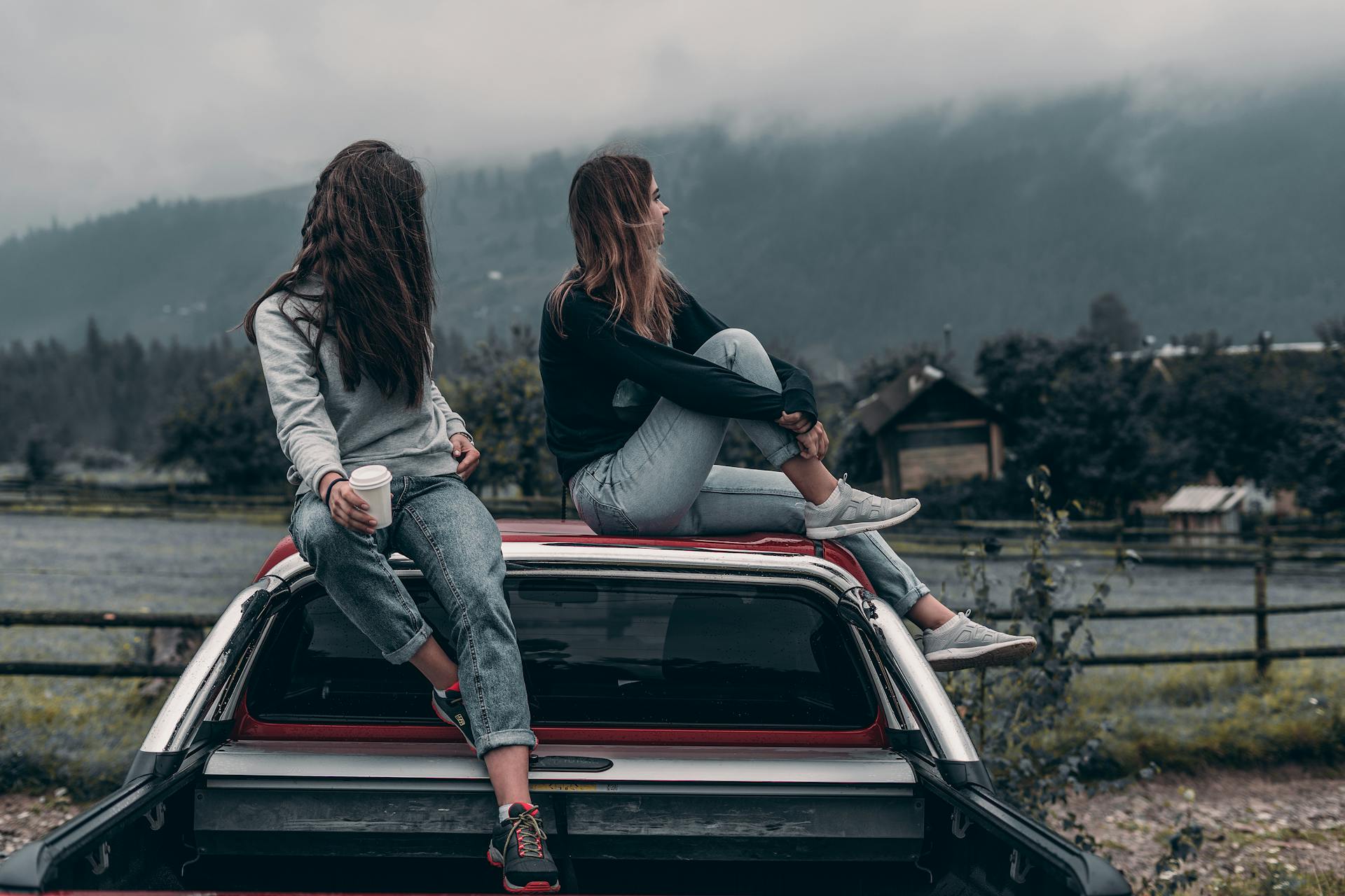 Zwei Frauen sitzen auf einem Fahrzeugdach | Quelle: Pexels