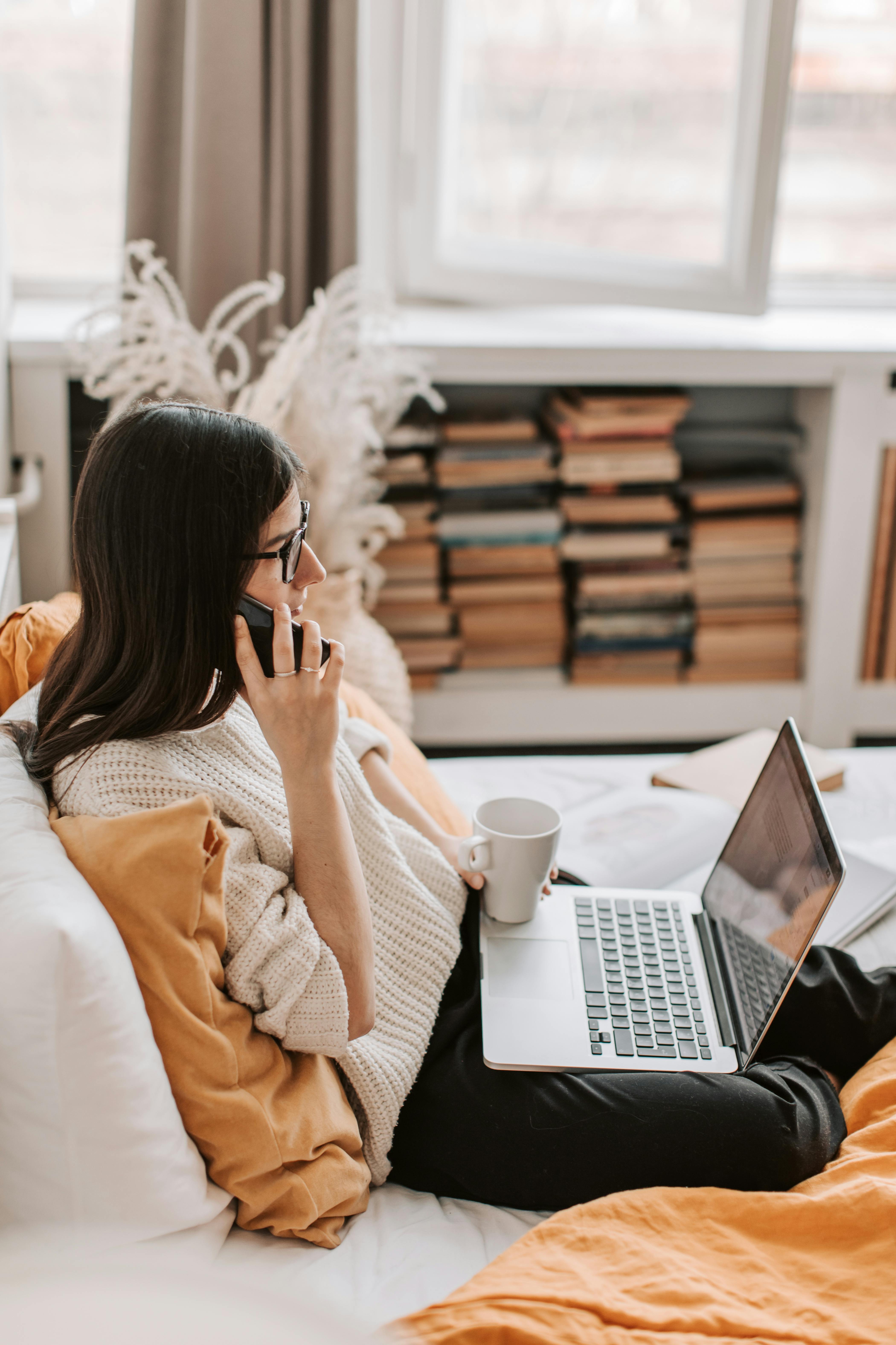 Eine Frau telefoniert zu Hause mit ihrem Laptop vor sich | Quelle: Pexels