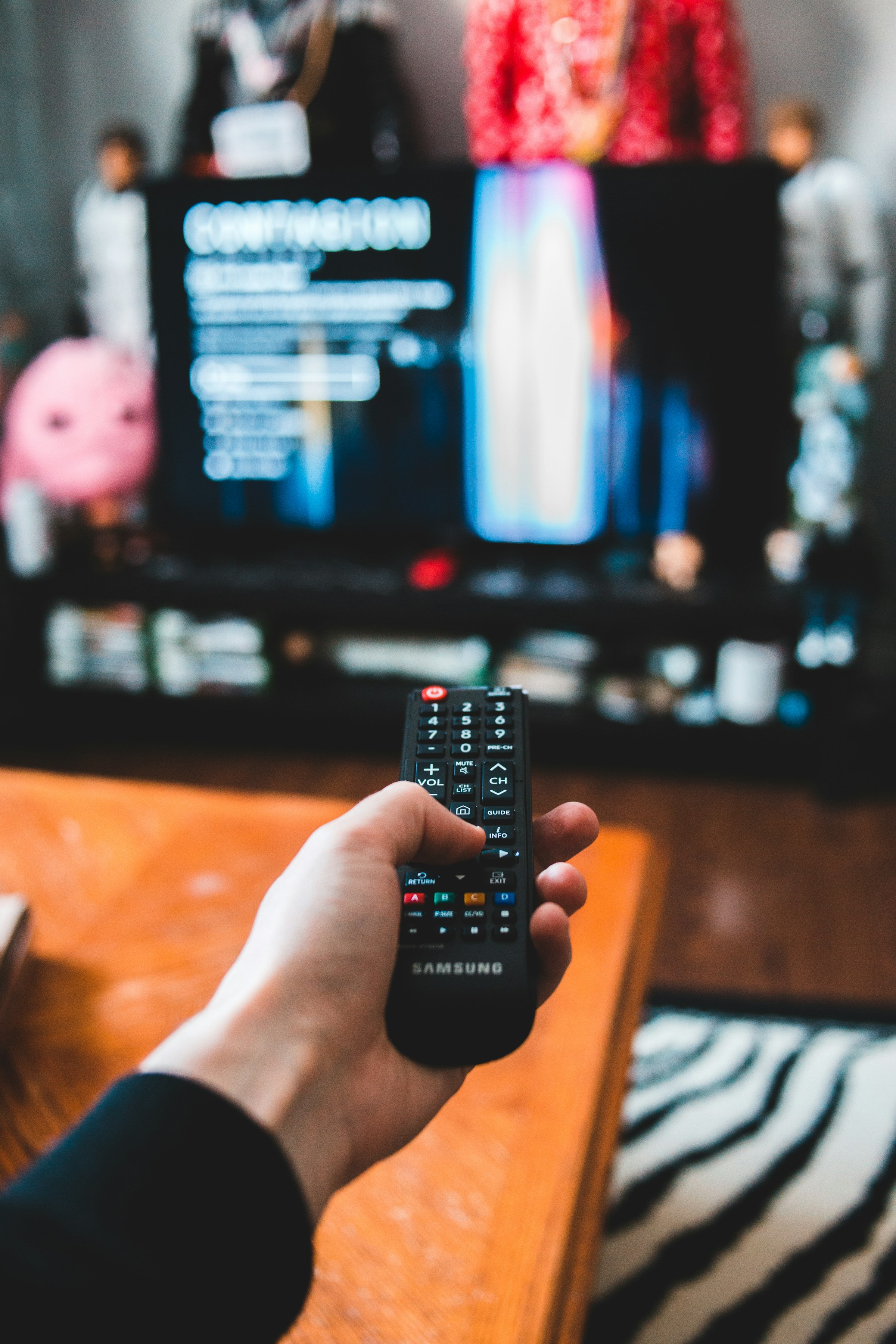 Eine Person hält eine TV-Fernbedienung | Quelle: Unsplash