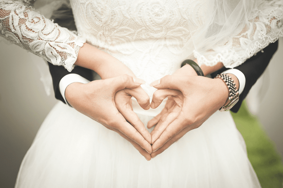 Eine Braut und ein Bräutigam formen ein Herz mit den Händen. | Quelle: Pixabay
