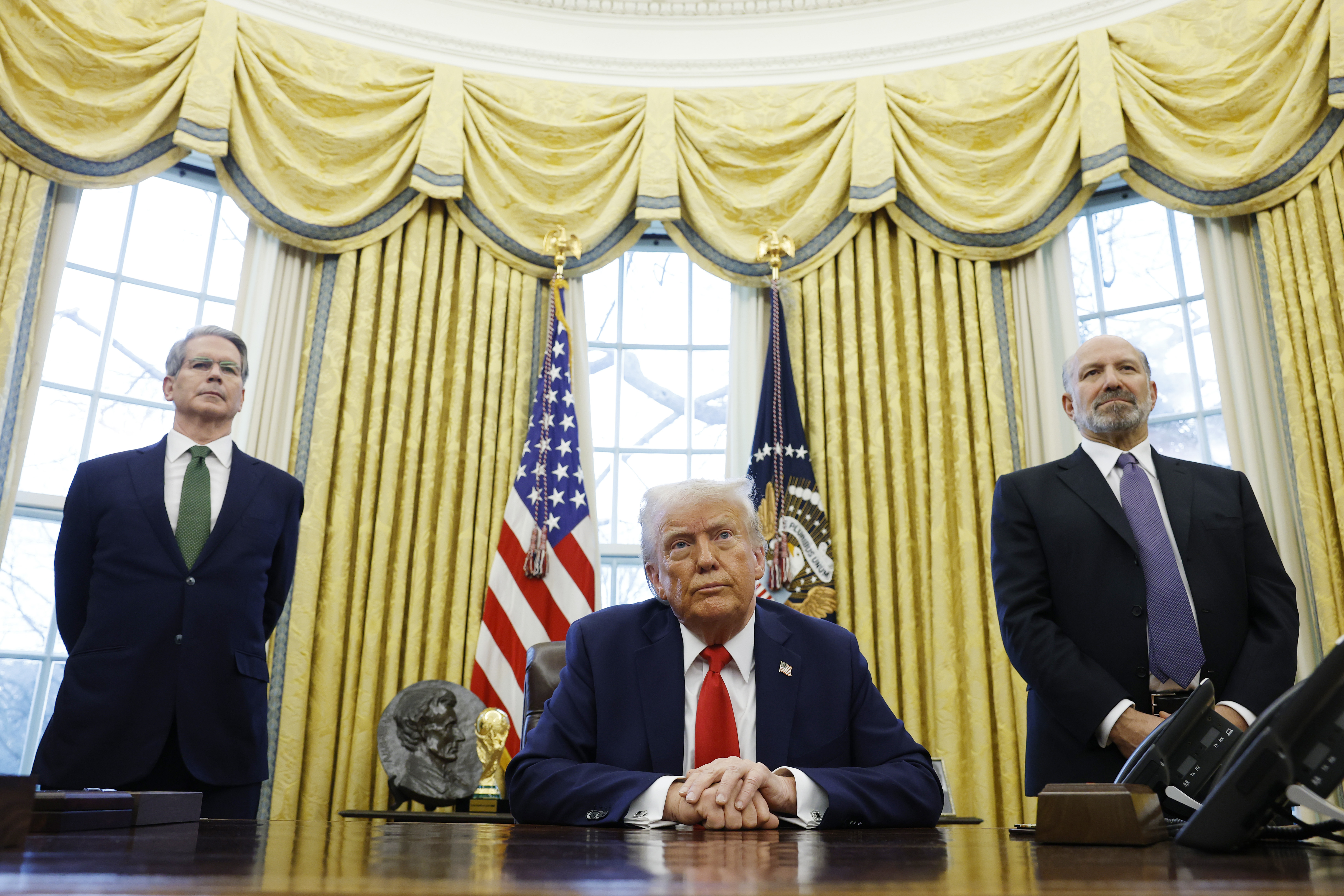 US-Finanzminister Scott Bessent und Howard Lutnick, der Kandidat von US-Präsident Donald Trump für das Amt des Handelsministers, stehen hinter Donald Trump, während er zu Reportern spricht. | Quelle: Getty Images