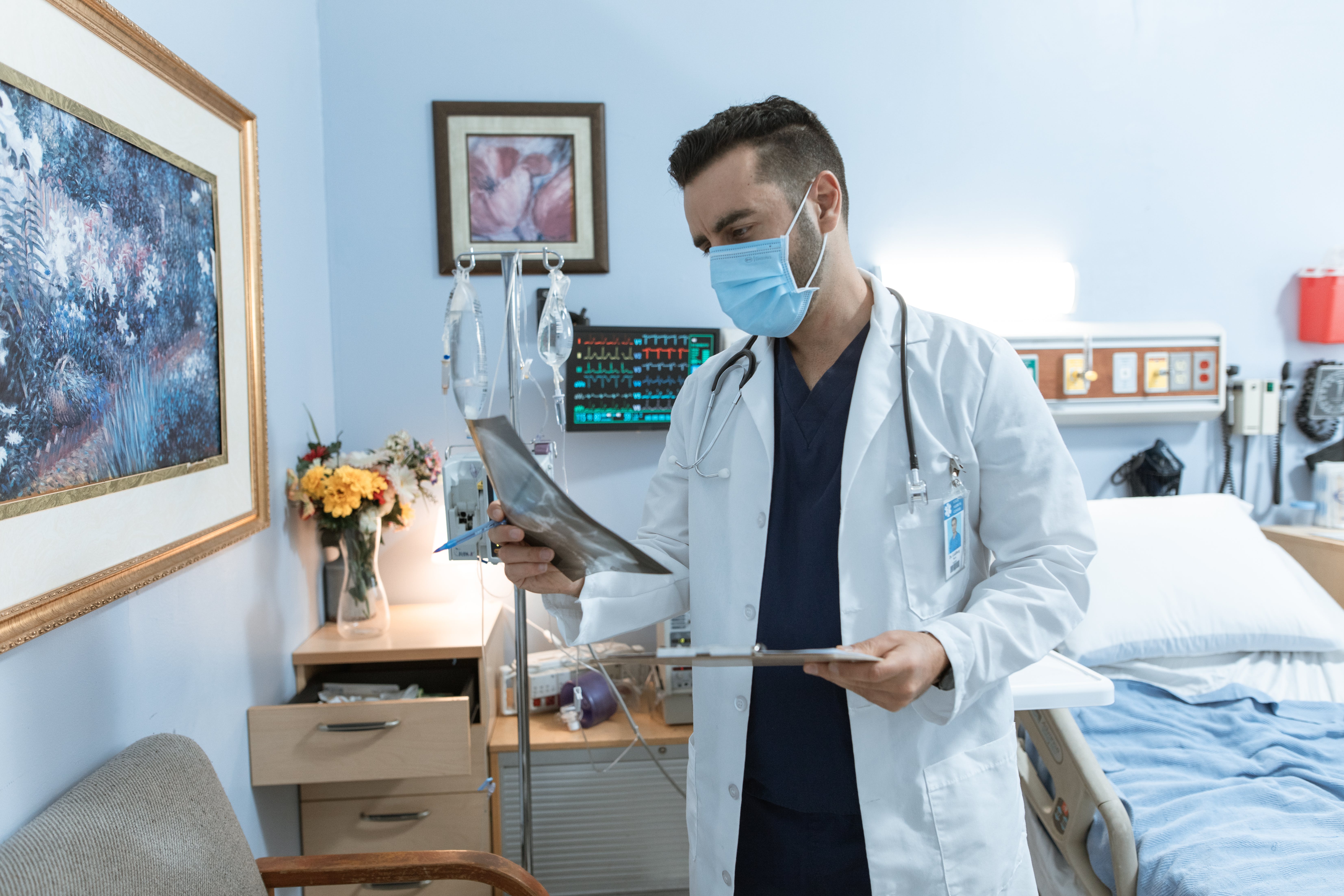 Ein Arzt sieht sich die Krankenakte eines Patienten an | Quelle: Pexels