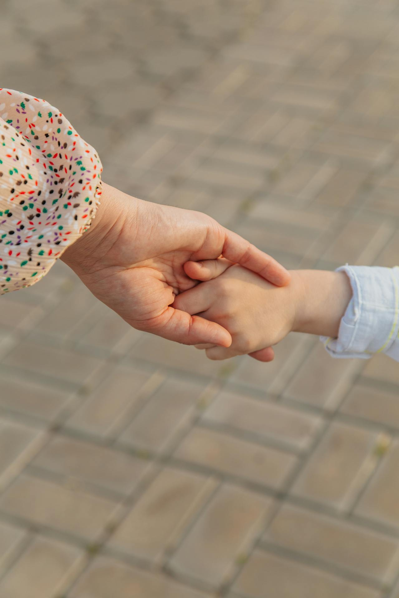 Ausgeschnittene Aufnahme einer Mutter, die die Hand ihres kleinen Sohnes hält | Quelle: Pexels