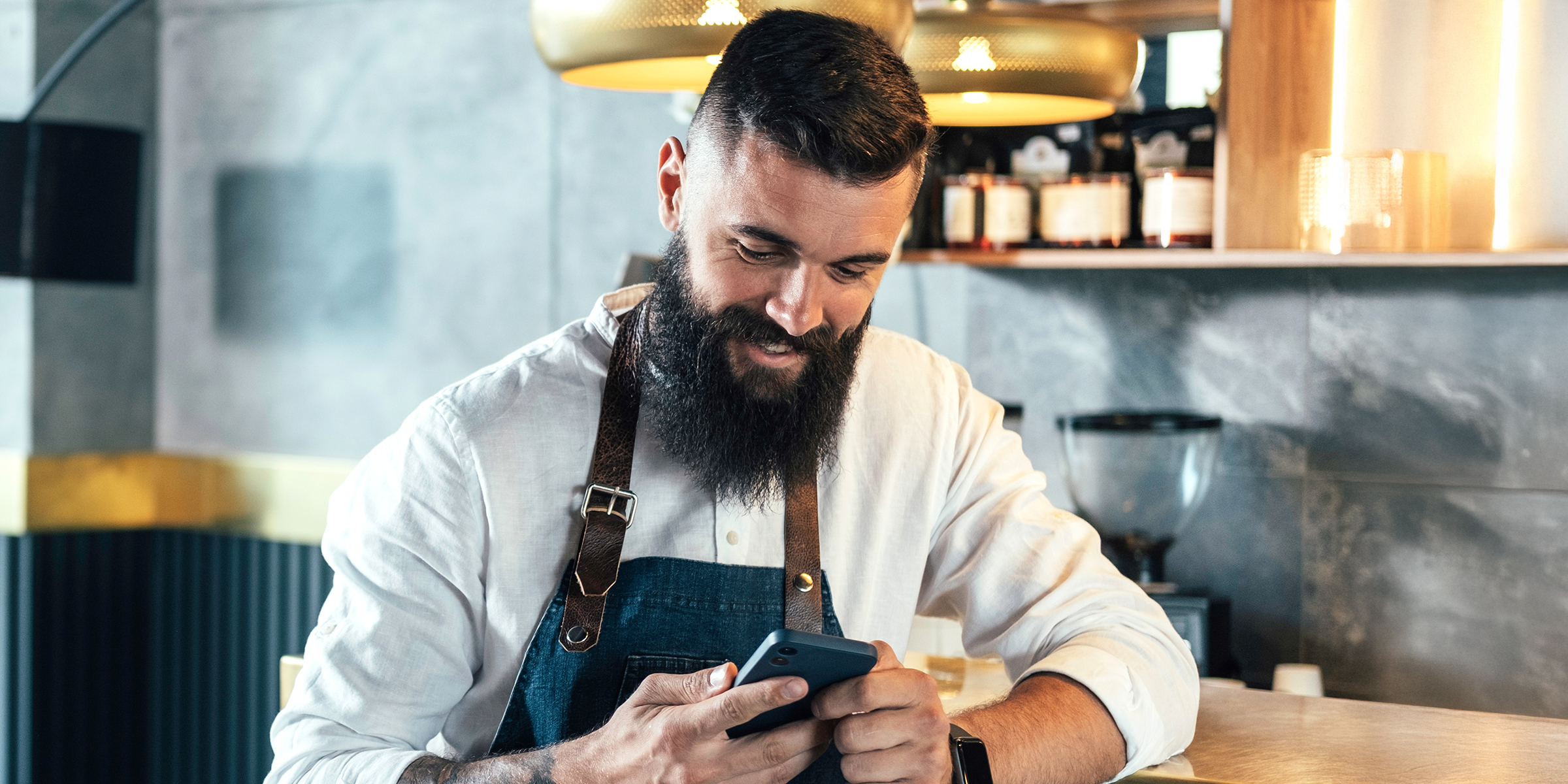 Ein Mann schaut auf sein Telefon und lacht | Quelle: Shutterstock