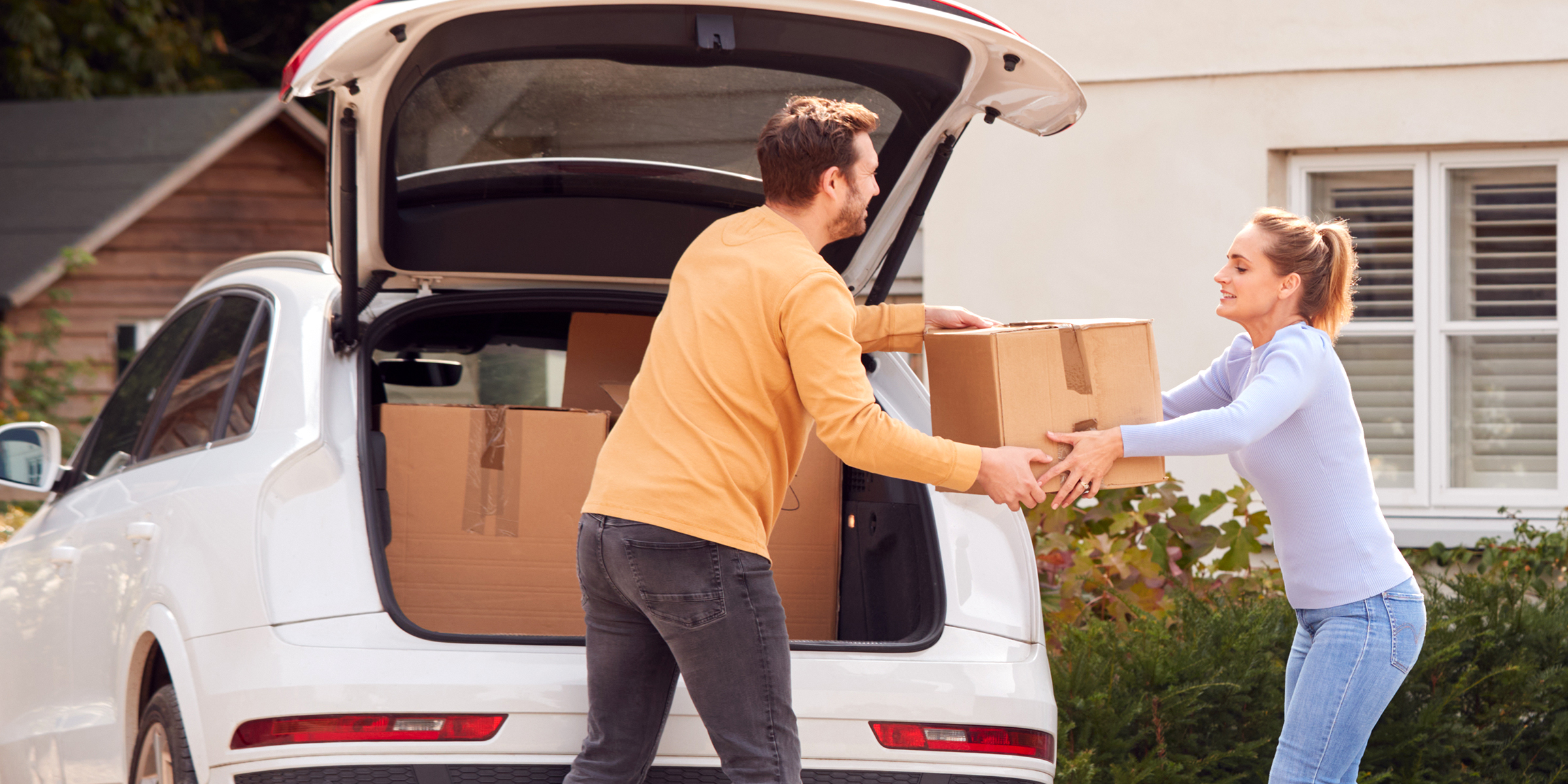 Mann und Frau laden Kisten in ein Auto | Quelle: Shutterstock