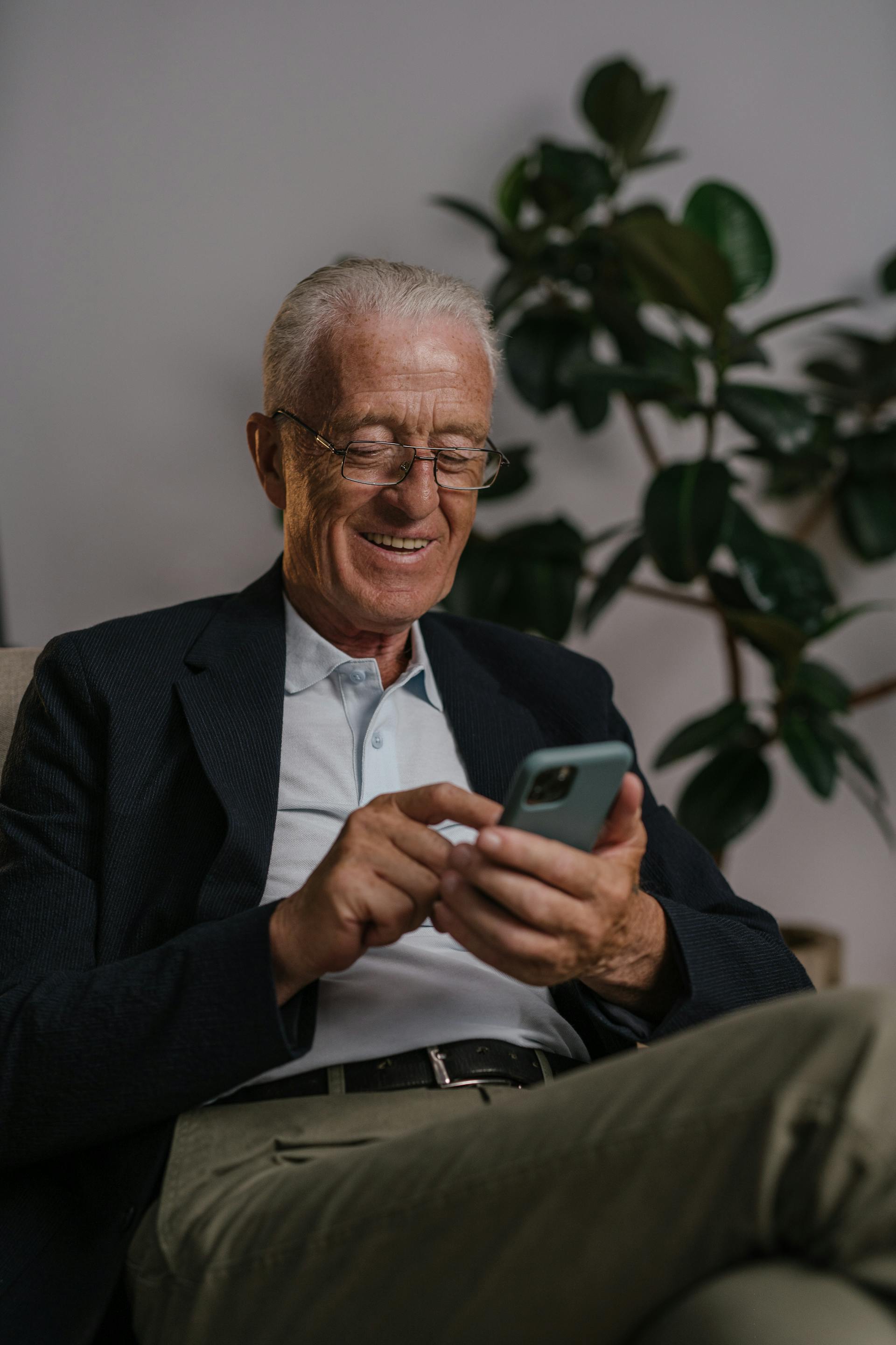 Ein glücklicher Mann an seinem Telefon | Quelle: Pexels