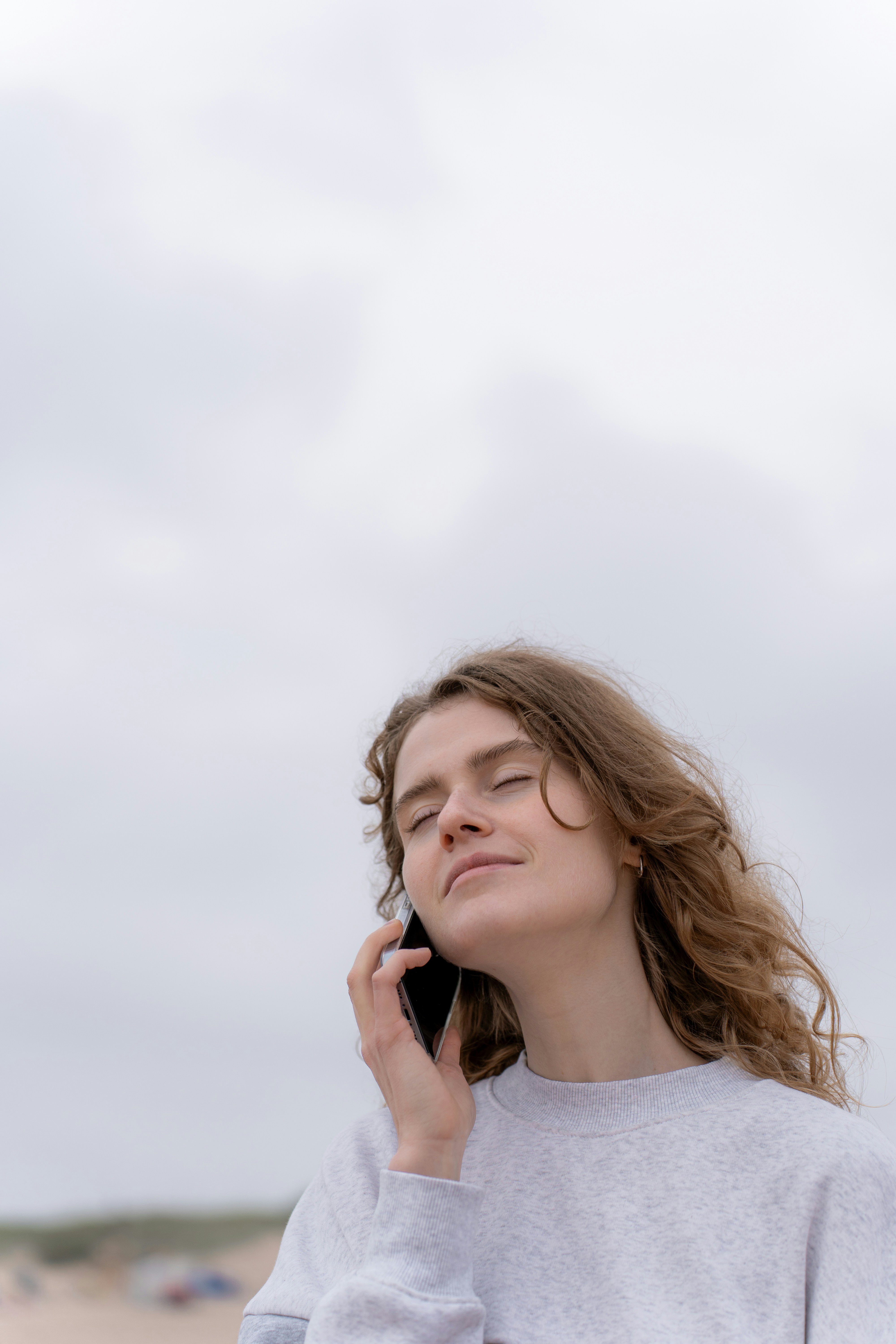 Eine Frau mit geschlossenen Augen beim Telefonieren | Quelle: Unsplash