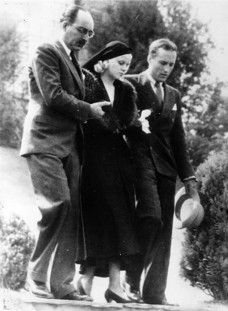 Die amerikanische Filmschauspielerin Jean Harlow wird von ihrem Stiefvater Mario Bello und einem Verwandten namens Donald Robertson auf dem Weg zur Beerdigung ihres Mannes begleitet. | Quelle: Getty Images