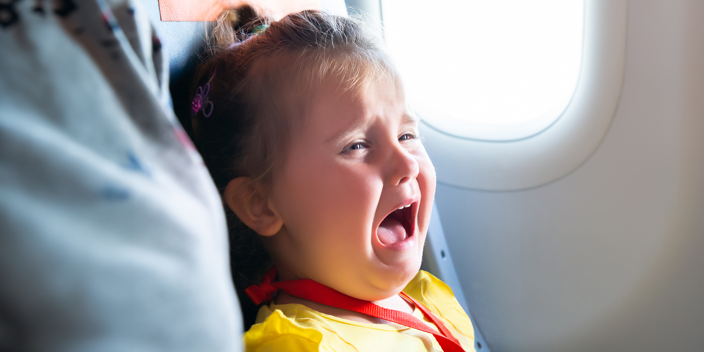 Ein kleines Mädchen weint in einem Flugzeug | Quelle: Shutterstock